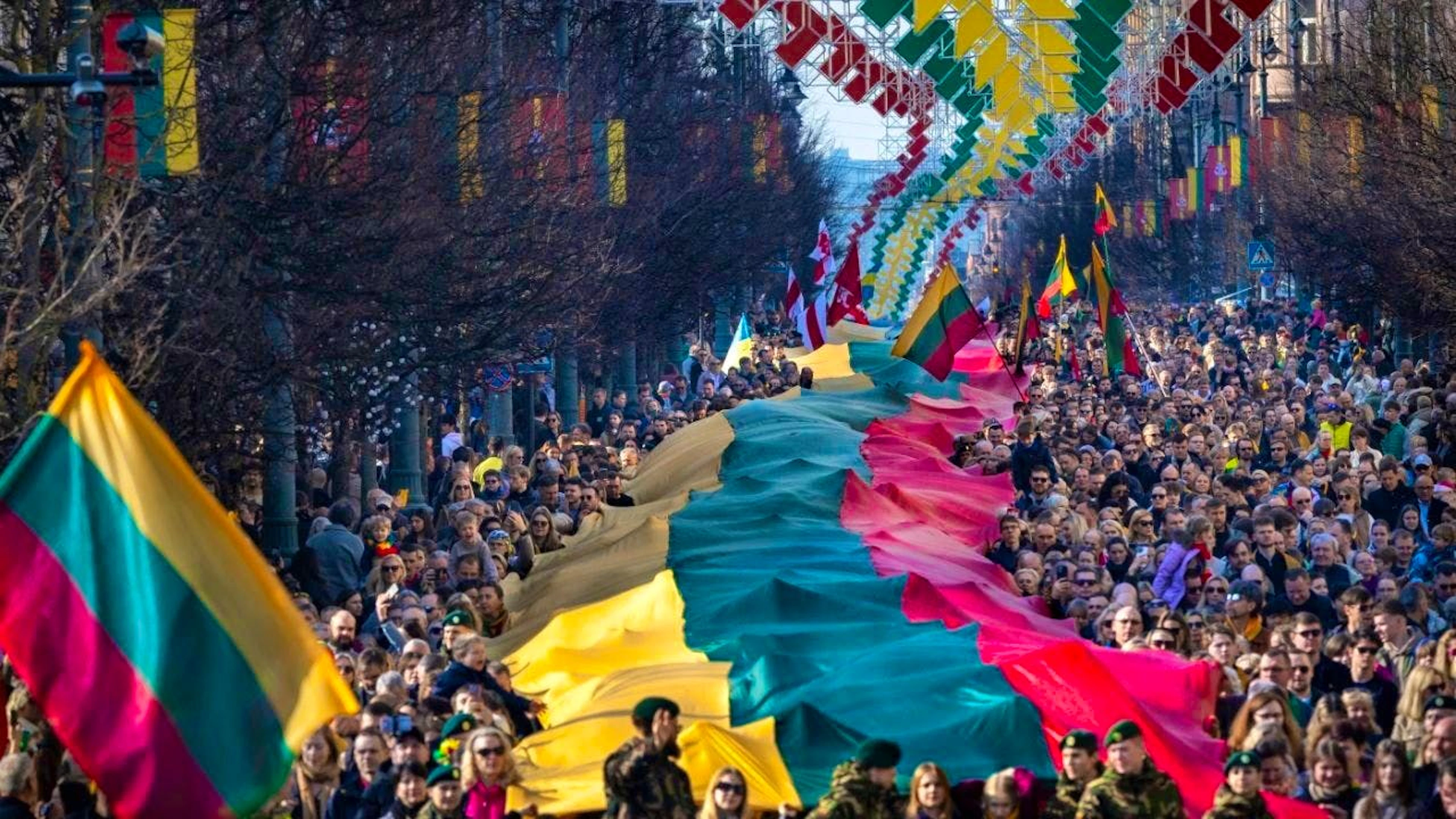 dpatopbilder - ARCHIV - People carry a huge Lithuanian flag during a celebration of the 35th anniversary of Lithuania's independence from the Soviet Union. Photo: Mindaugas Kulbis/AP/dpa/Archive image