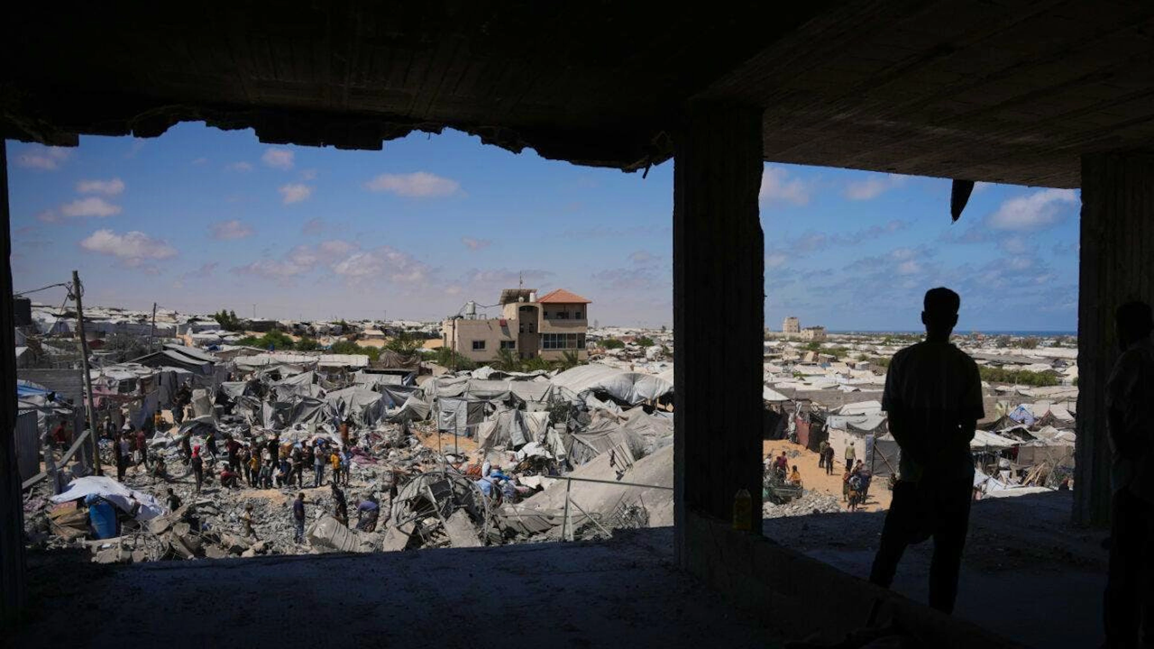 dpatopbilder – Palästinenser inspizieren die Trümmer eines Gebäudes, das bei einem israelischen Luftangriff im südlichen Gazastreifen zerstört wurde. Foto: Abdel Kareem Hana/AP/dpa