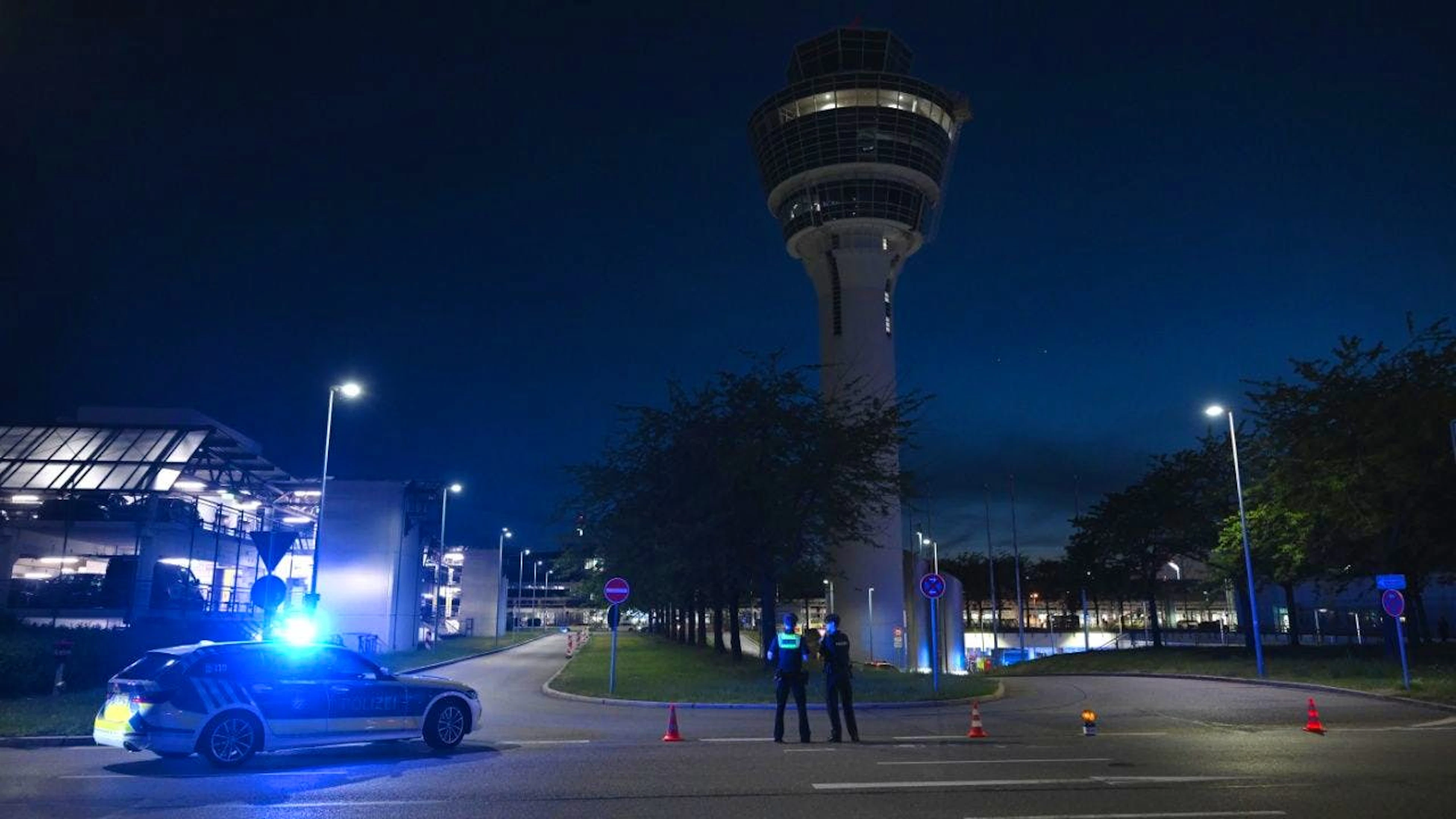 Polizei steht vor dem Tower des Münchner Flughafens. Am Flughafen München ist der Flugbetrieb teilweise eingestellt worden. Foto: Sven Hoppe/dpa