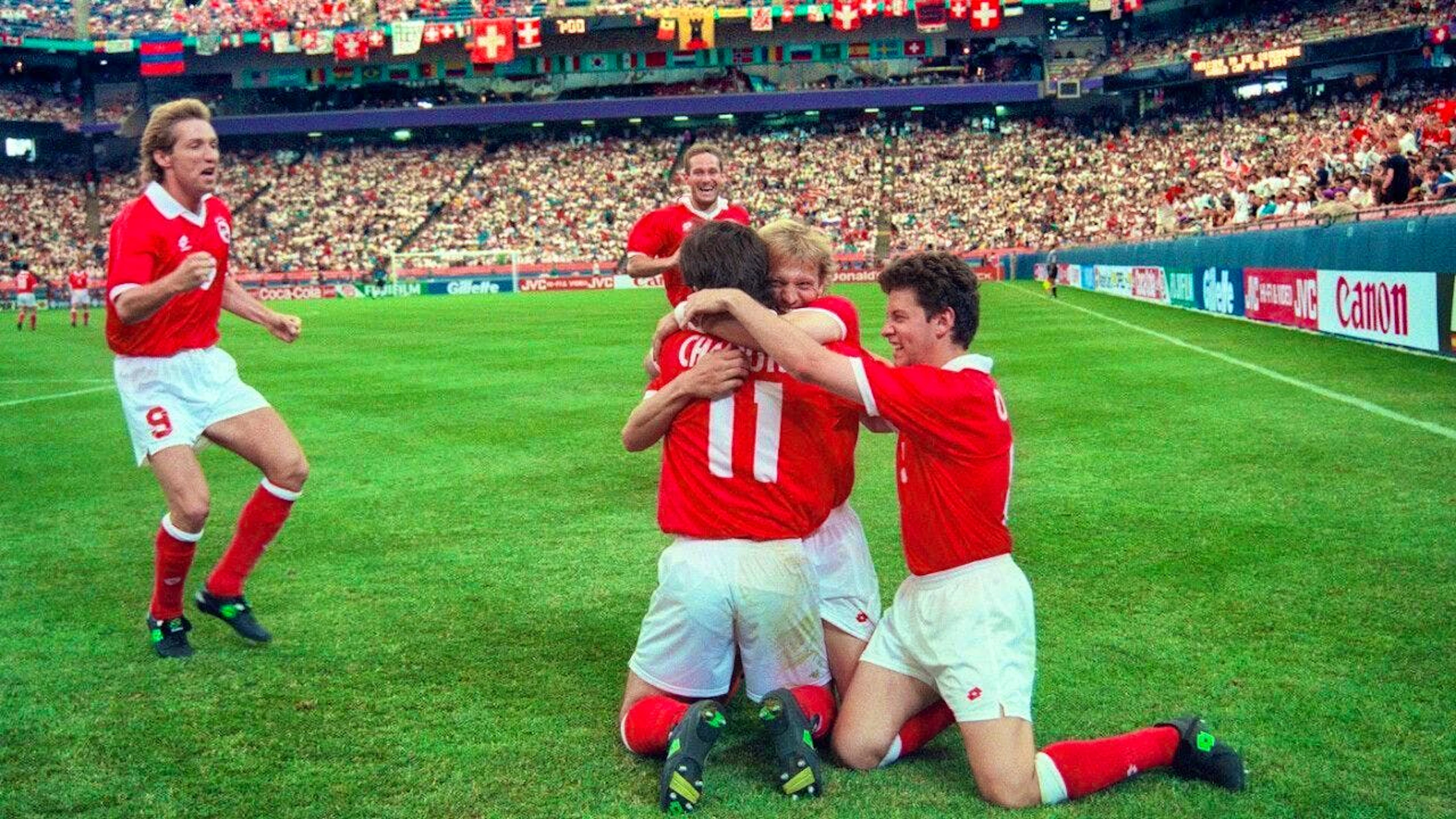 Adrian Knup and Christoph Ohrel embrace Stéphane Chapuisat (11) after his goal for 2:1 in the group match of the 1994 World Cup against Romania, Yvan Quentin joins them in the background