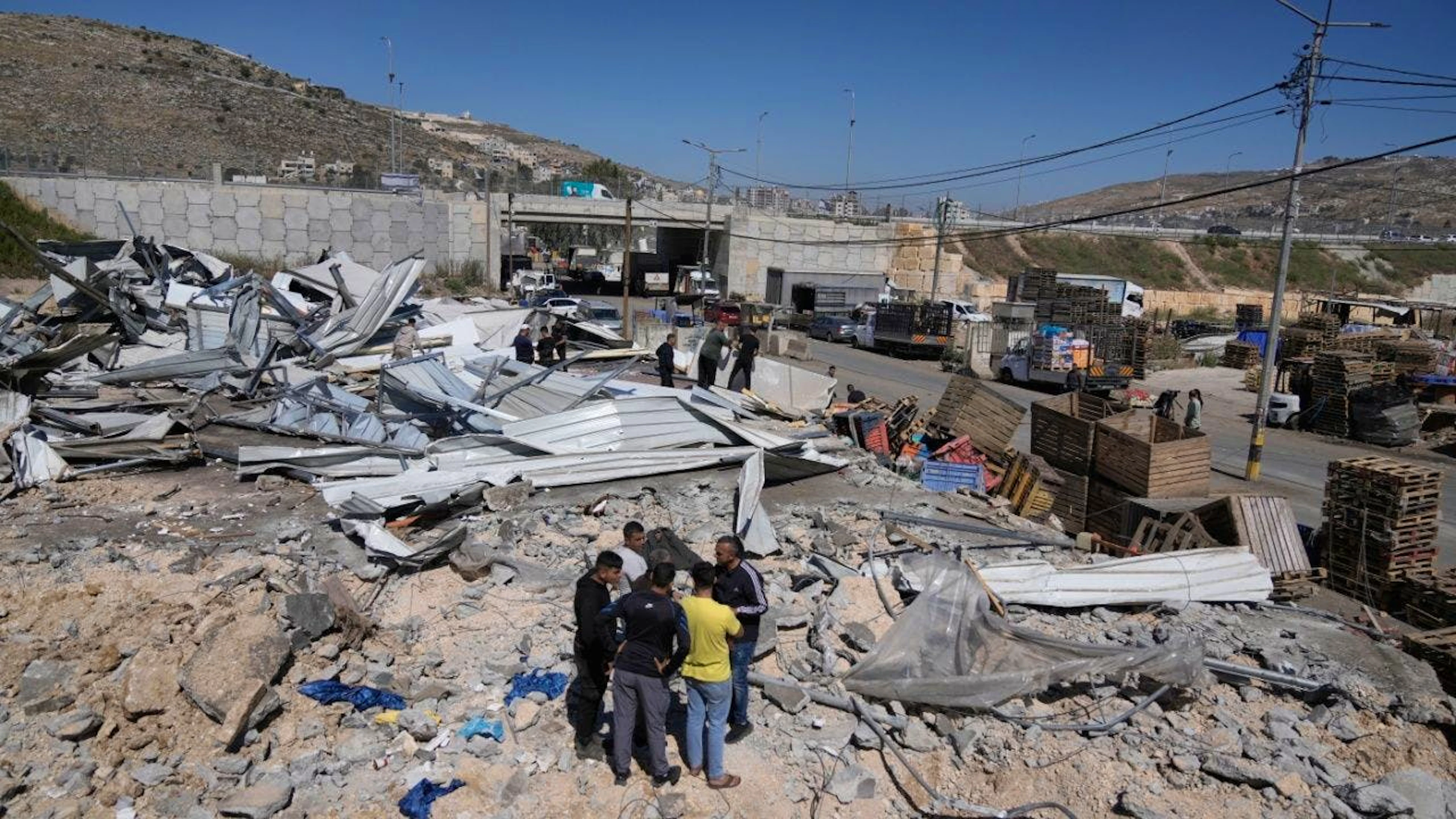 ARCHIV – Palästinenser gehen durch die Trümmer ihrer Häuser, nachdem die israelischen Behörden einen grossen Teil des Hauptgemüsemarktes des Westbankdorfes Beita, südöstlich von Nablus, am Montag, den 1. Juni 2026, zerstört haben. Foto: Majdi Mohammed/AP/dpa