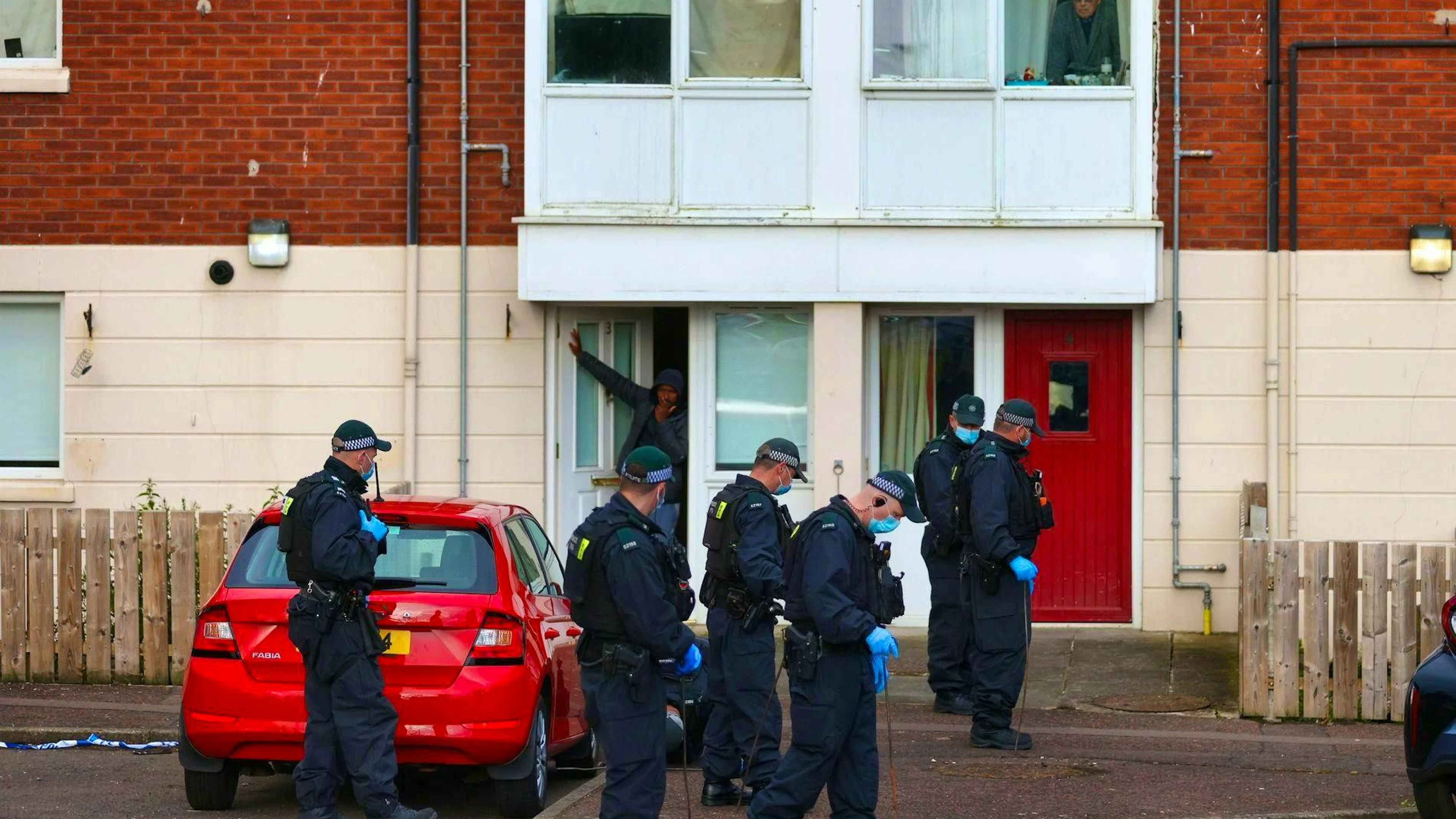 Police search the area around the crime scene in a residential area of north Belfast.