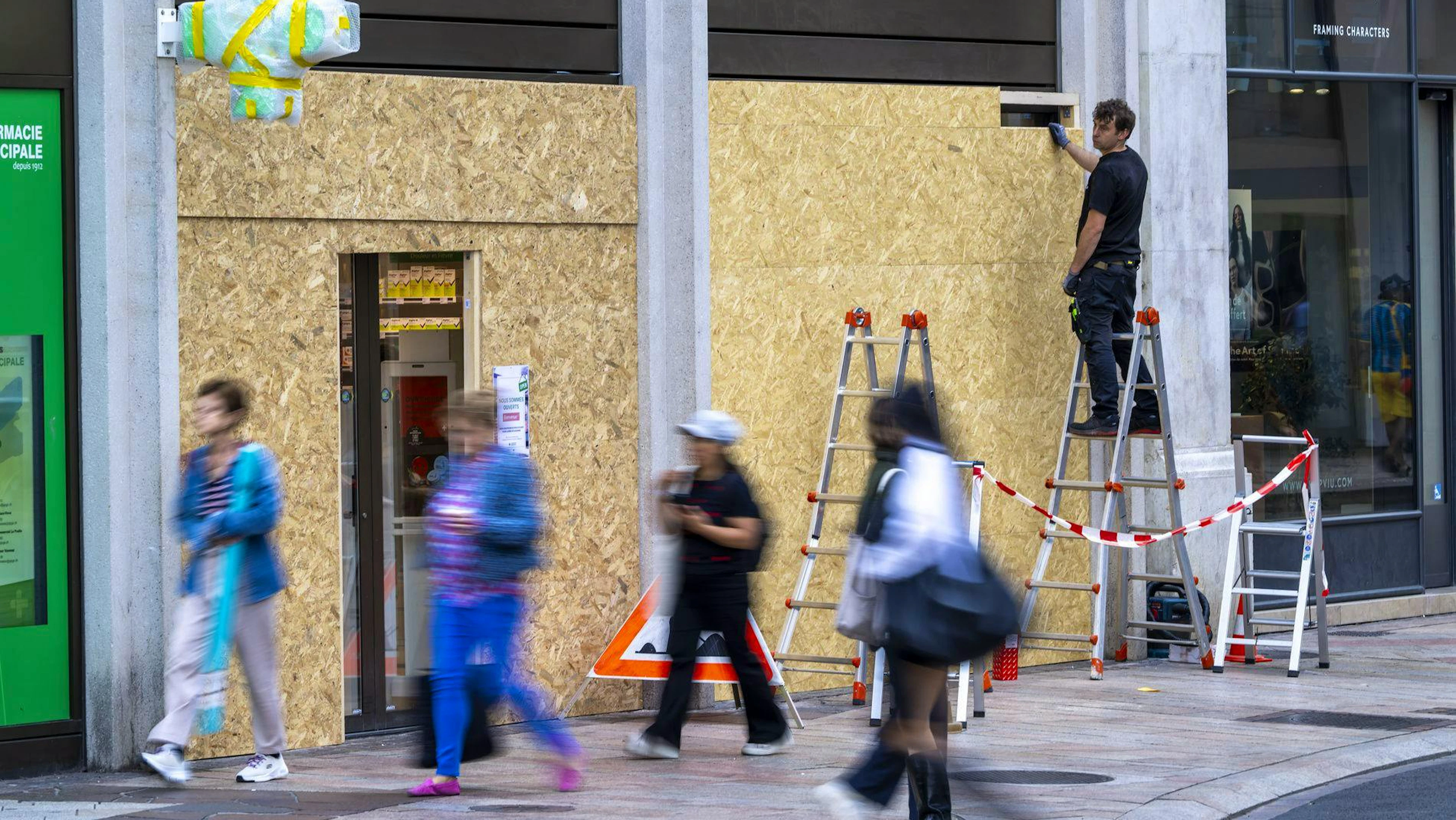 Des ouvriers installent une barricade en bois pour protéger la façade d'un bâtiment en prévision des manifestations contre le sommet du G7 à Évian, près de Genève, en Suisse, le mercredi 10 juin 2026. Les manifestations contre le sommet du G7 se concentreront ce week-end à Genève, une ville voisine choisie par les militants pour son accessibilité par rapport au périmètre de haute sécurité mis en place à Évian. (KEYSTONE/Martial Trezzini)
