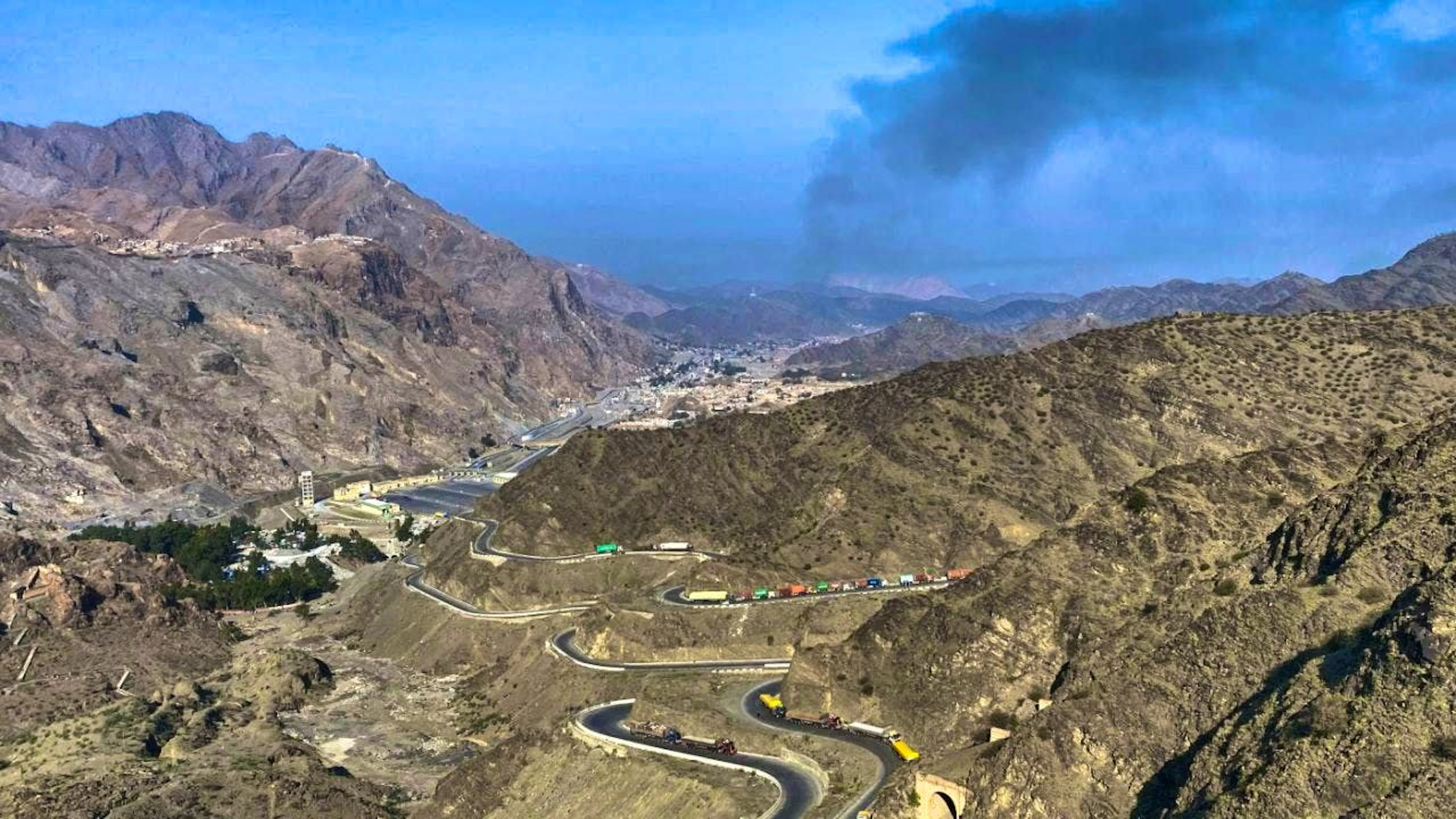 ARCHIVE - Smoke rises from the Afghan side after clashes between Pakistani and Afghan forces near the Torkham border crossing in Pakistan as trucks are parked on the side of the road. Photo: Maaz Awan/AP/dpa