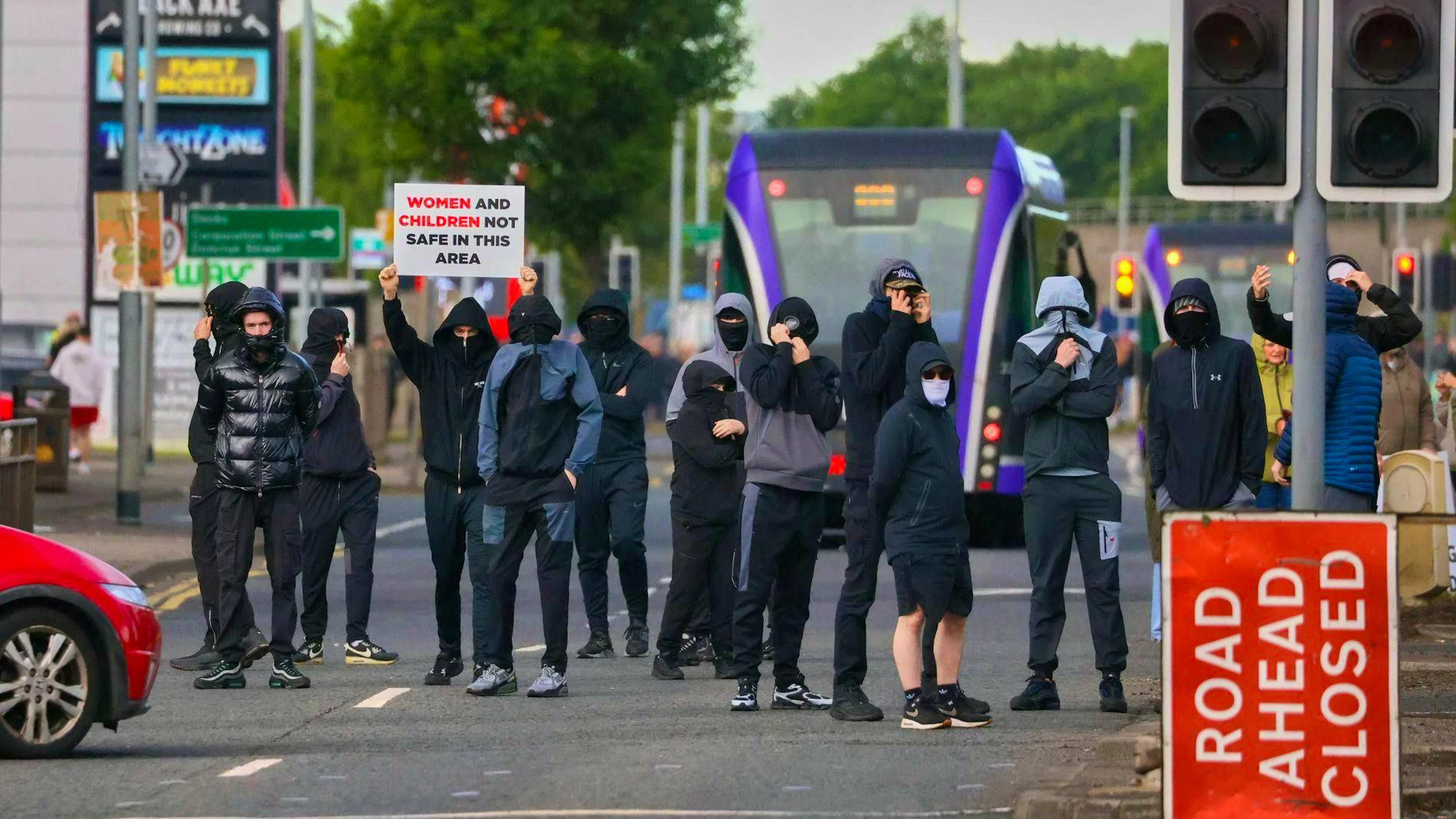 Masked people gather in Belfast on Tuesday. The knife attack took place on Monday. 