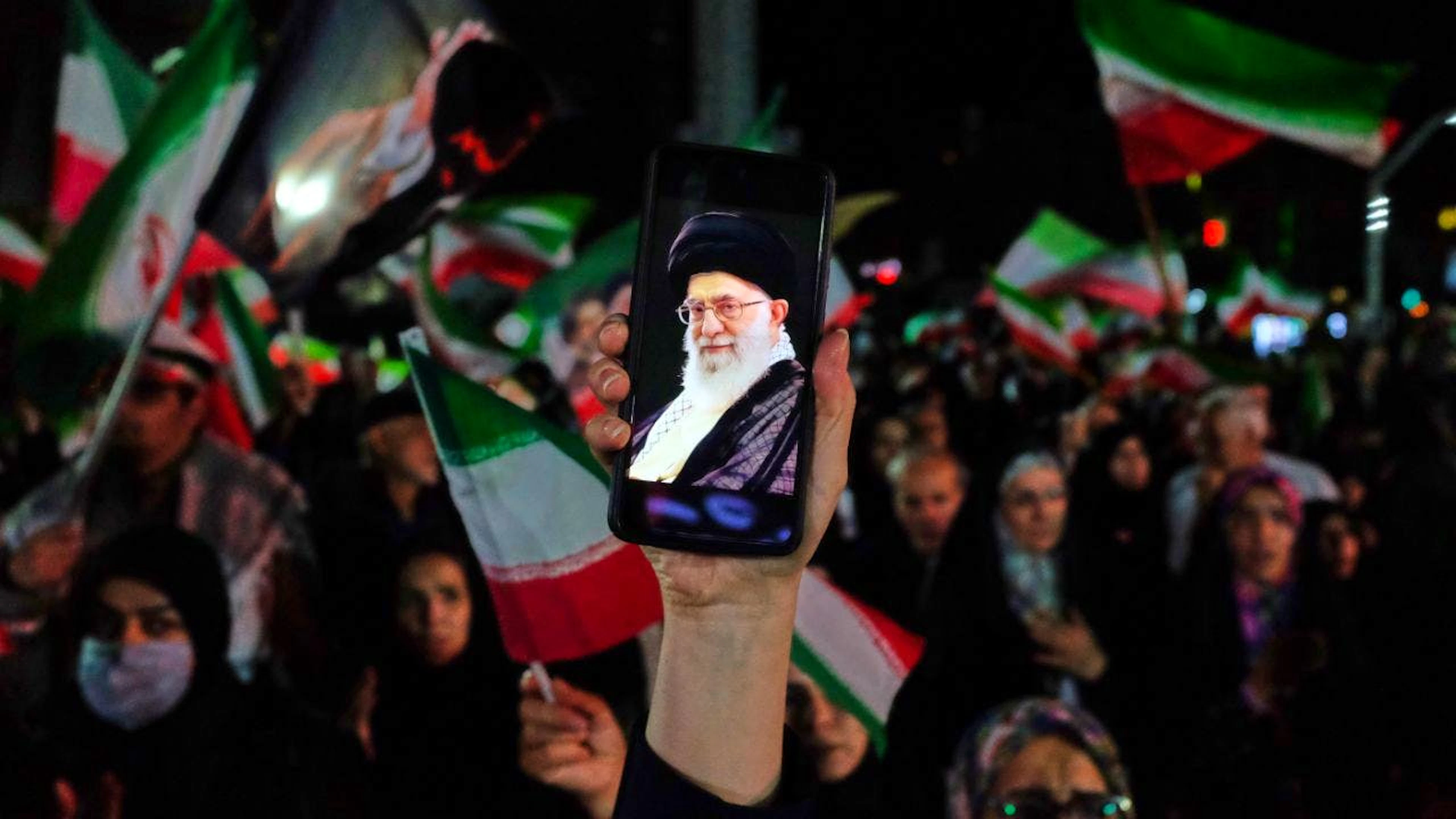 ARCHIV – Ein regierungsfreundlicher Demonstrant hält während einer Kundgebung ein Handy hoch, auf dessen Bildschirm ein Bild des verstorbenen iranischen Obersten Führers Ajatollah Ali Chamenei zu sehen ist. Foto: Vahid Salemi/AP/dpa (Archivbild)