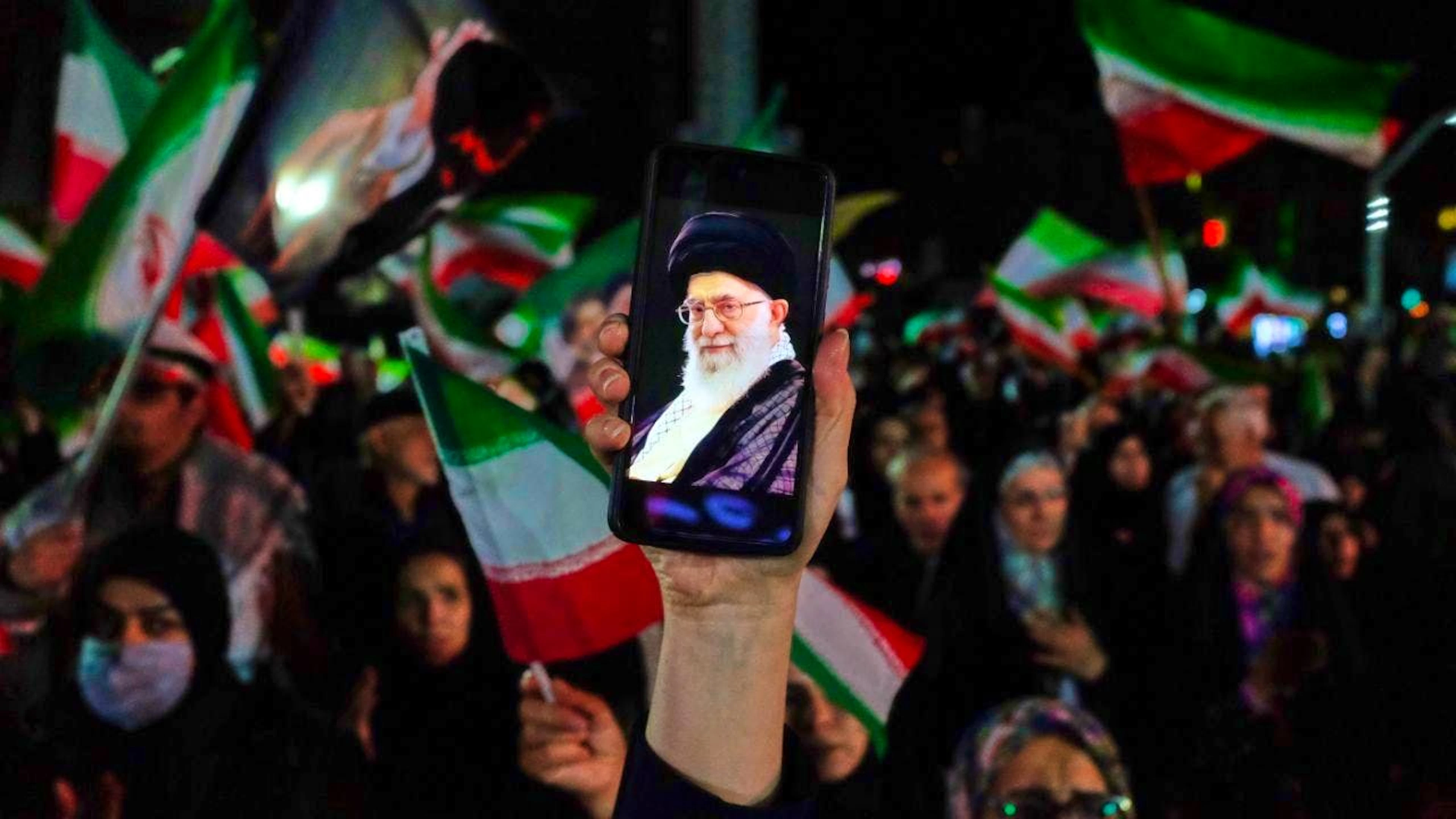 ARCHIVE – A pro-government demonstrator holds up a cell phone during a rally, displaying an image of the late Iranian Supreme Leader Ayatollah Ali Khamenei on the screen. Photo: Vahid Salemi/AP/dpa (Archive photo)