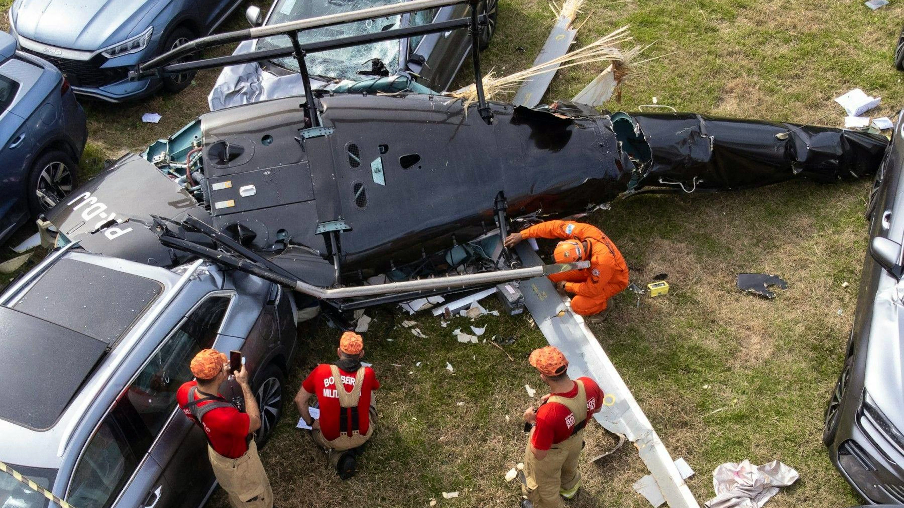 Ausgebrannte Fahrzeuge und Trümmer sind zu sehen, nachdem zwei Helikopter in der Luft zusammengestossen und auf den Parkplatz eines Autohauses in Rio de Janeiro gestürzt sind.