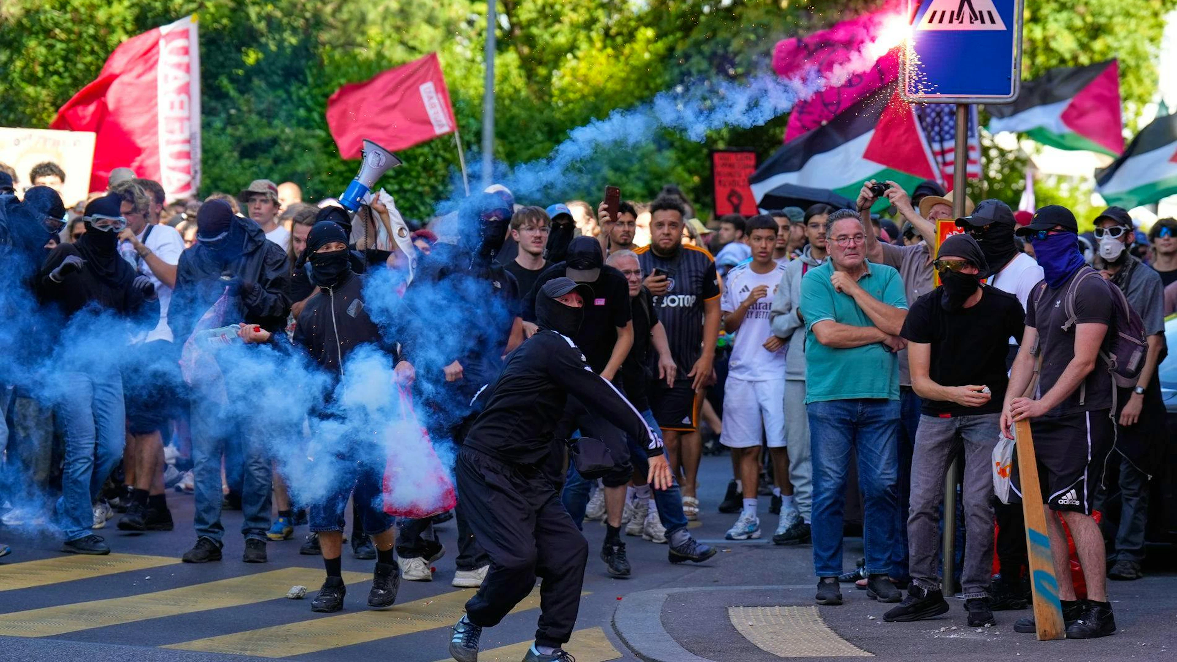 Un manifestant lance une fusée éclairante lors d'une manifestation « No G7 » à Genève.