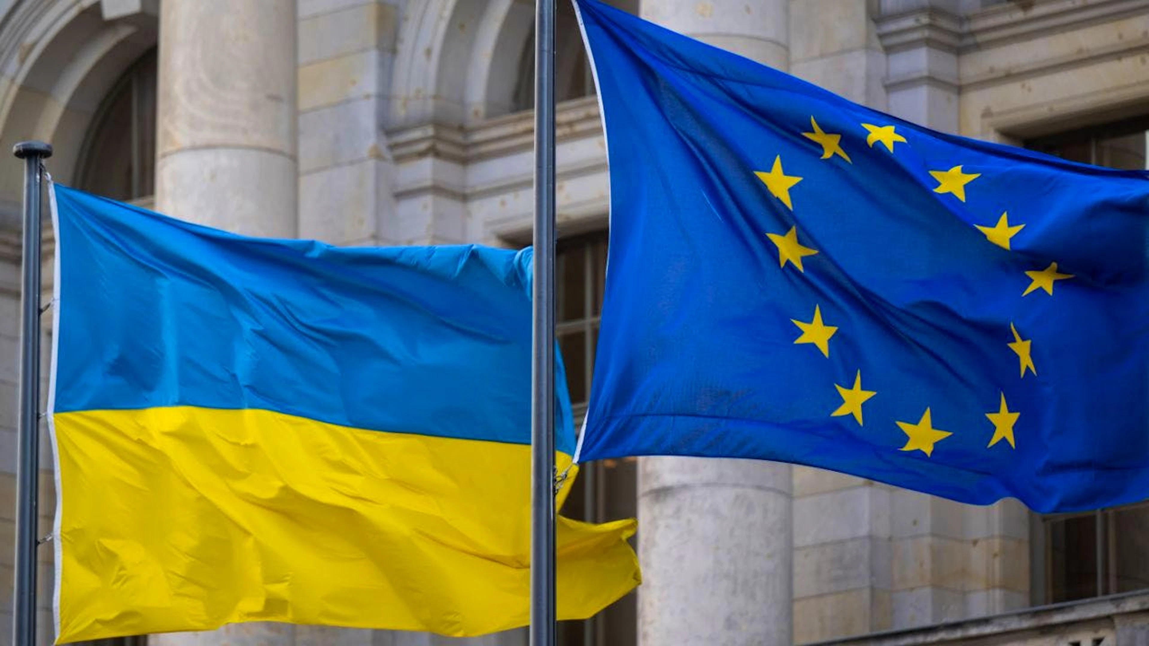 ARCHIV – Die Nationalflagge der Ukraine und die Flagge der EU wehen im Wind. Foto: Monika Skolimowska/dpa