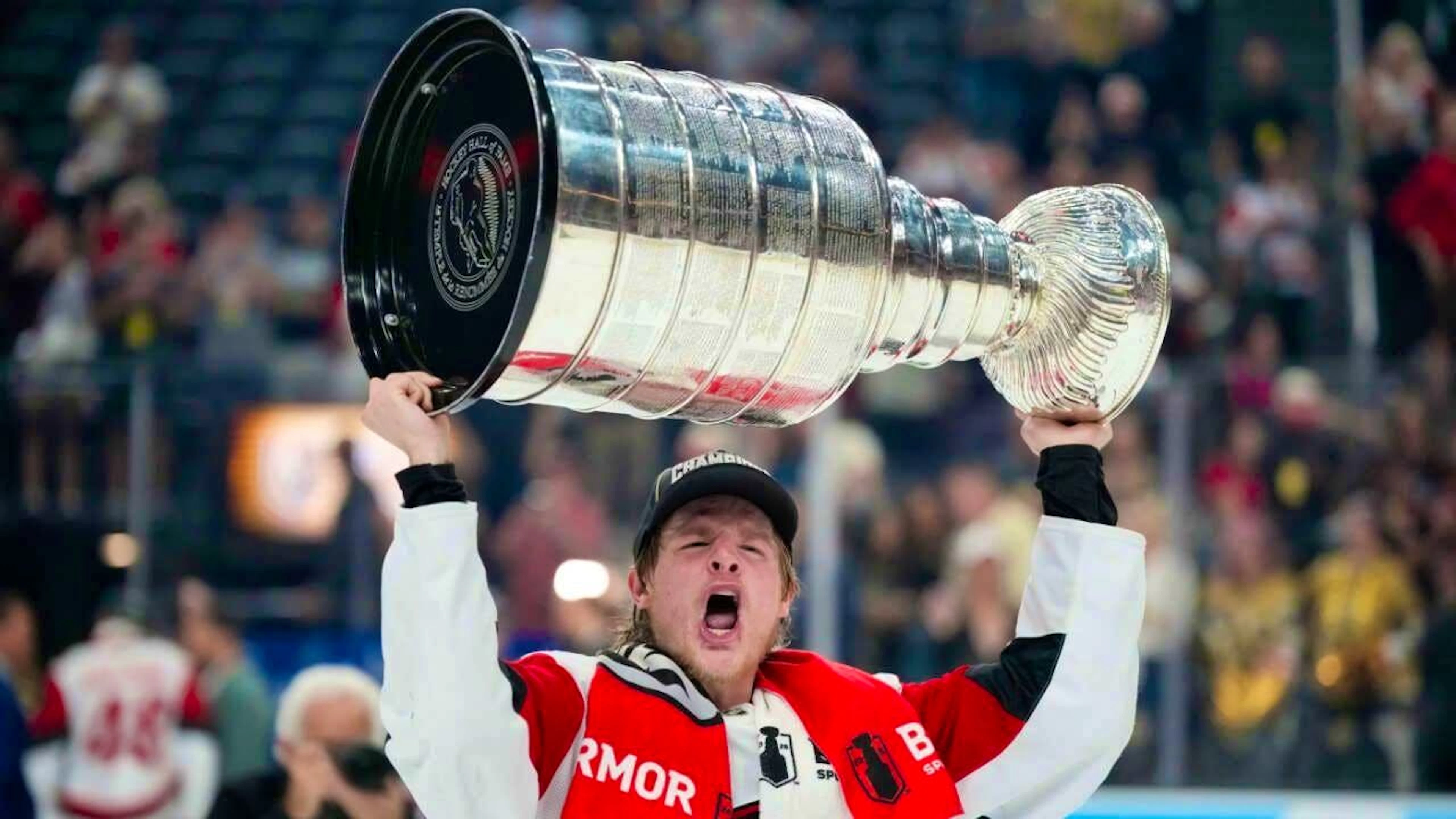 Jackson Blake, a Hurricanes player, hoists the most prestigious trophy in ice hockey