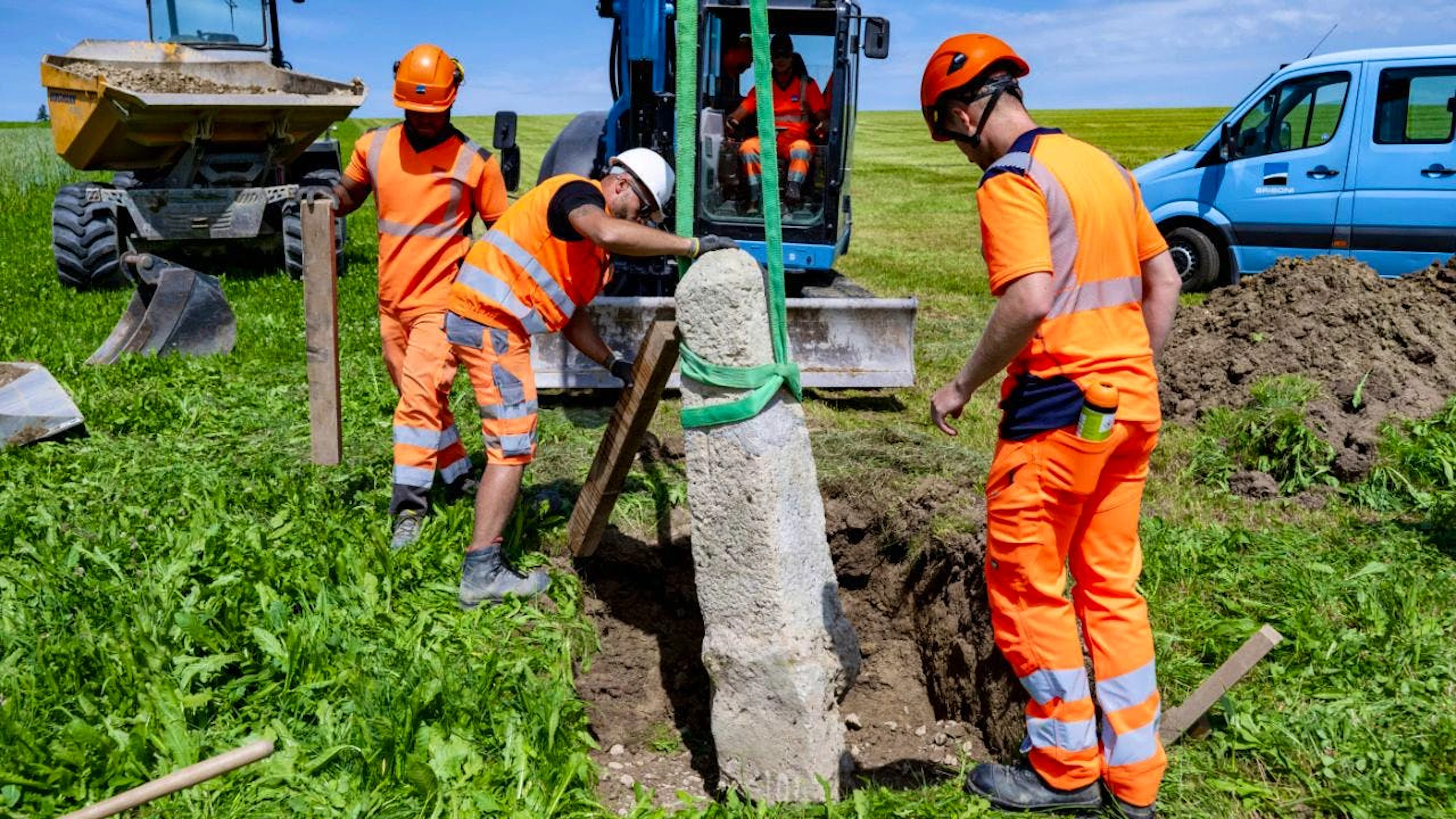 Bauarbeiter versetzen im freiburgischen Siviriez einen Grenzstein.