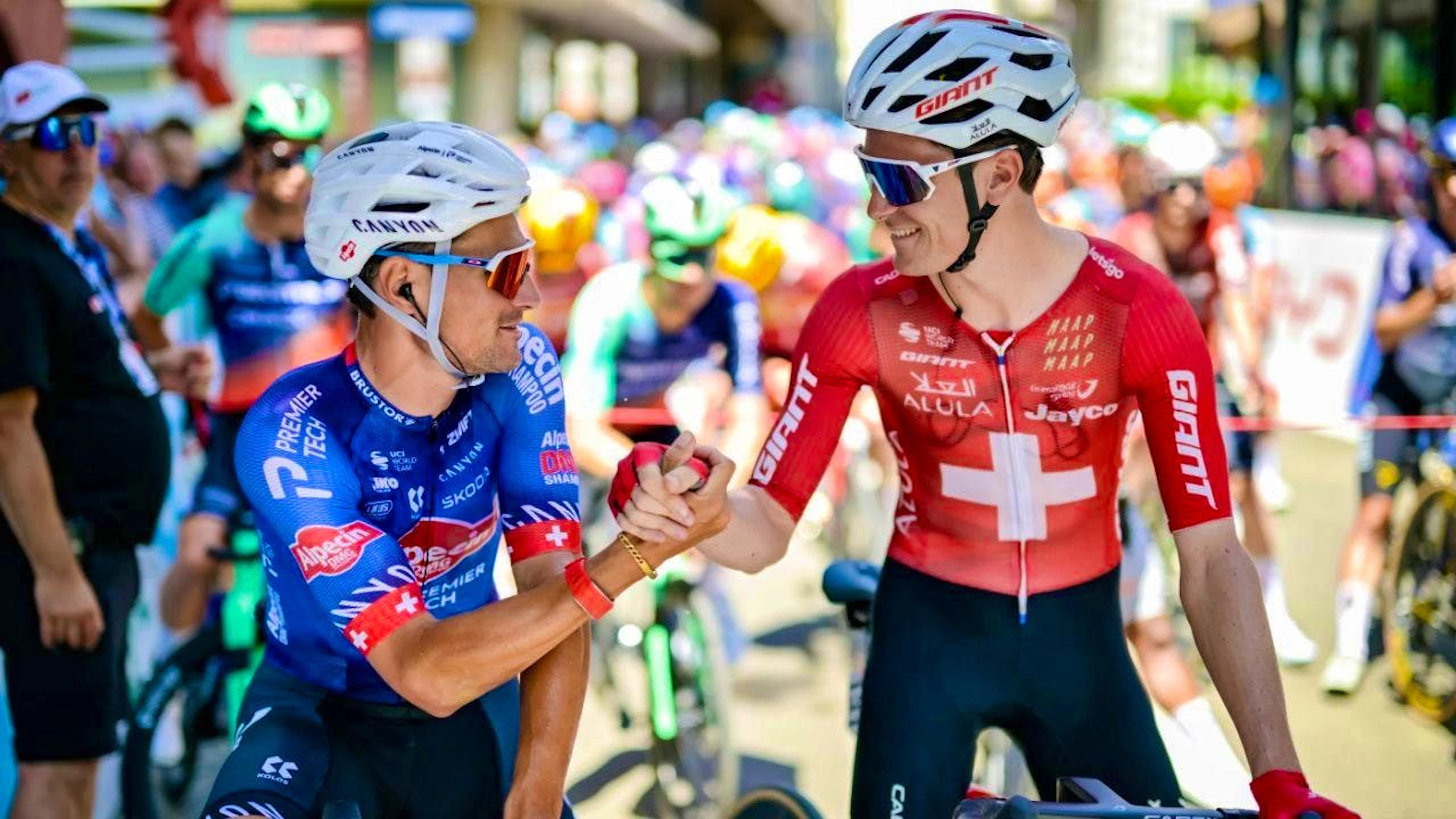 Silvan Dillier (left) and Swiss champion Mauro Schmid greet each other before the start of Stage 1 of the Tour de Suisse in Sondrio