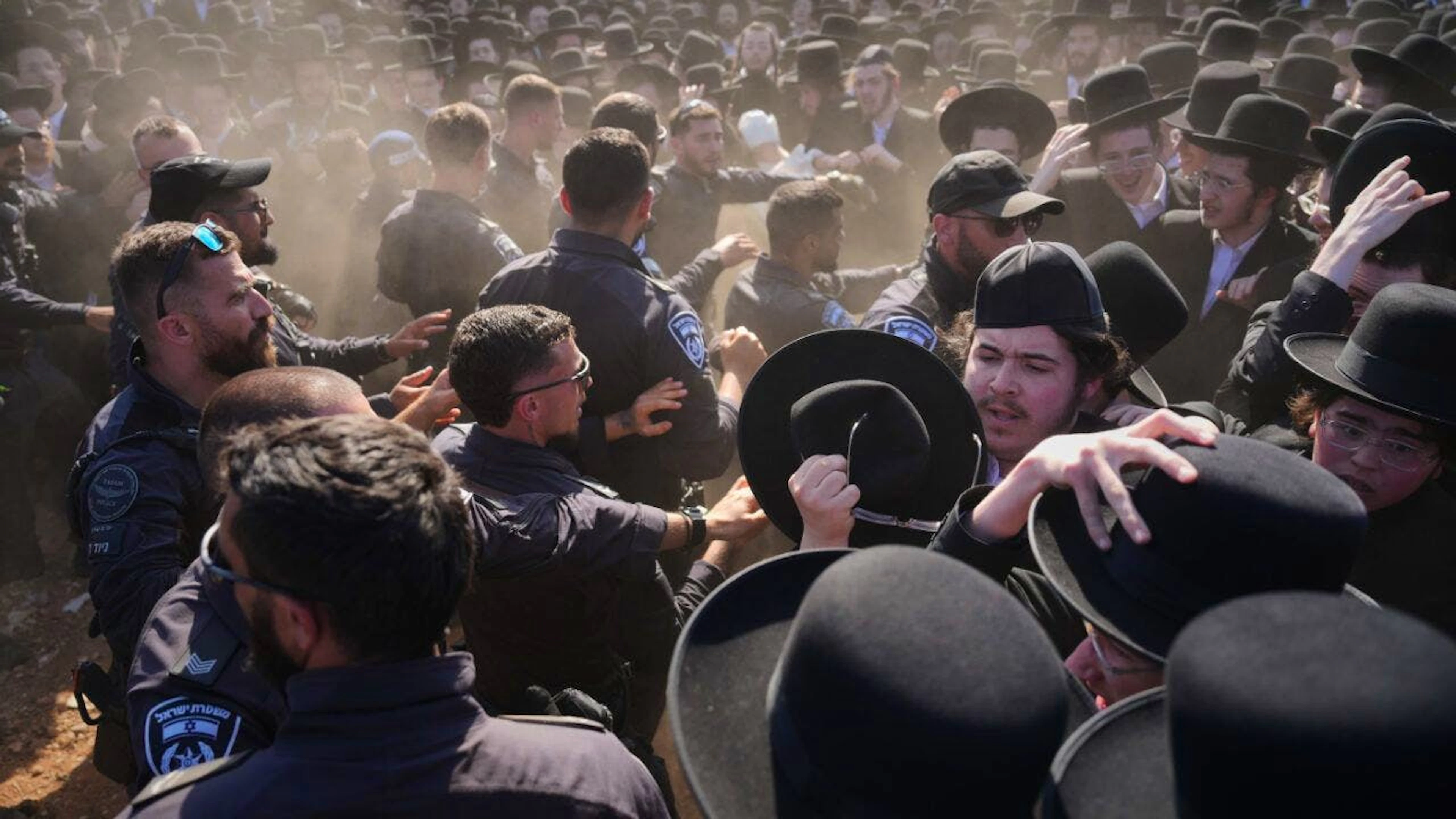 Ultraorthodoxe jüdische Männer geraten während einer Demonstration gegen die Wehrpflicht für alle vor einem Militärgefängnis in der Nähe von Kfar Yona, Israel, am Mittwoch mit der Polizei aneinader. Die Demonstranten und fordern die Freilassung inhaftierter Wehrdienstverweigerer. Foto: Ariel Schalit/AP/dpa
