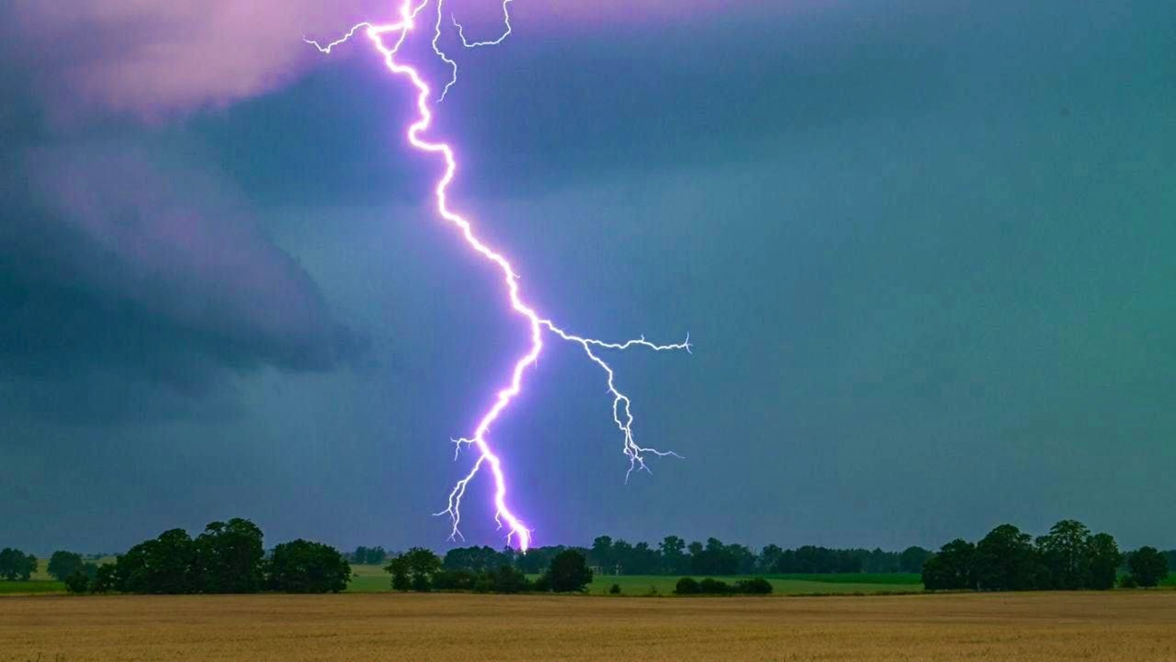ARCHIVE – Summer thunderstorm over a field. Photo: Patrick Pleul/dpa/Archive photo