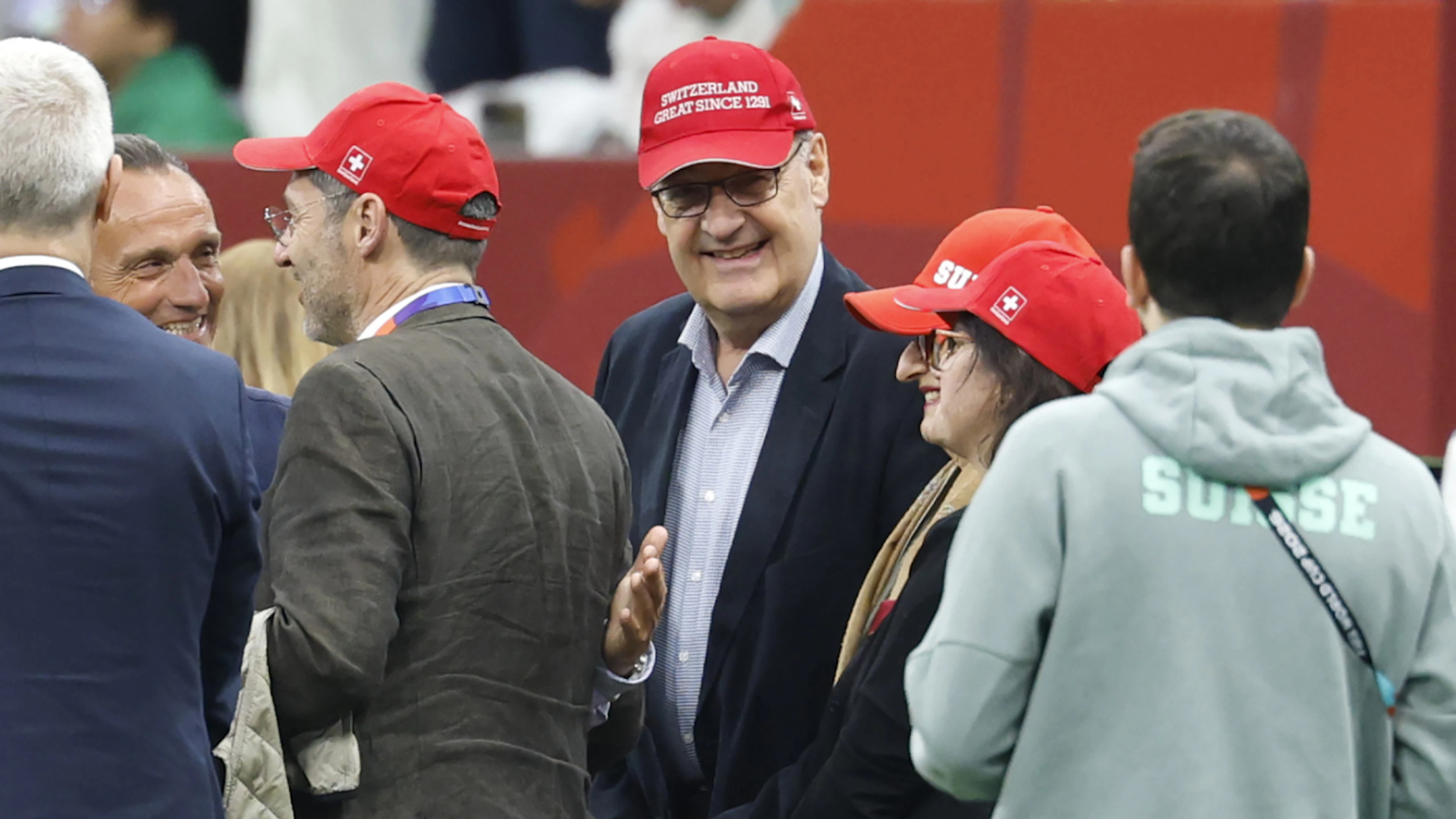 Il presidente della Confederazione Guy Parmelin immortalato prima della partita di calcio disputata a Vancouver tra la Svizzera e l'Algeria. Lo slogan indossato dal consigliere federale «Switzerland Great since 1291», ricorda ironicamente quello coniato da Donald Trump.