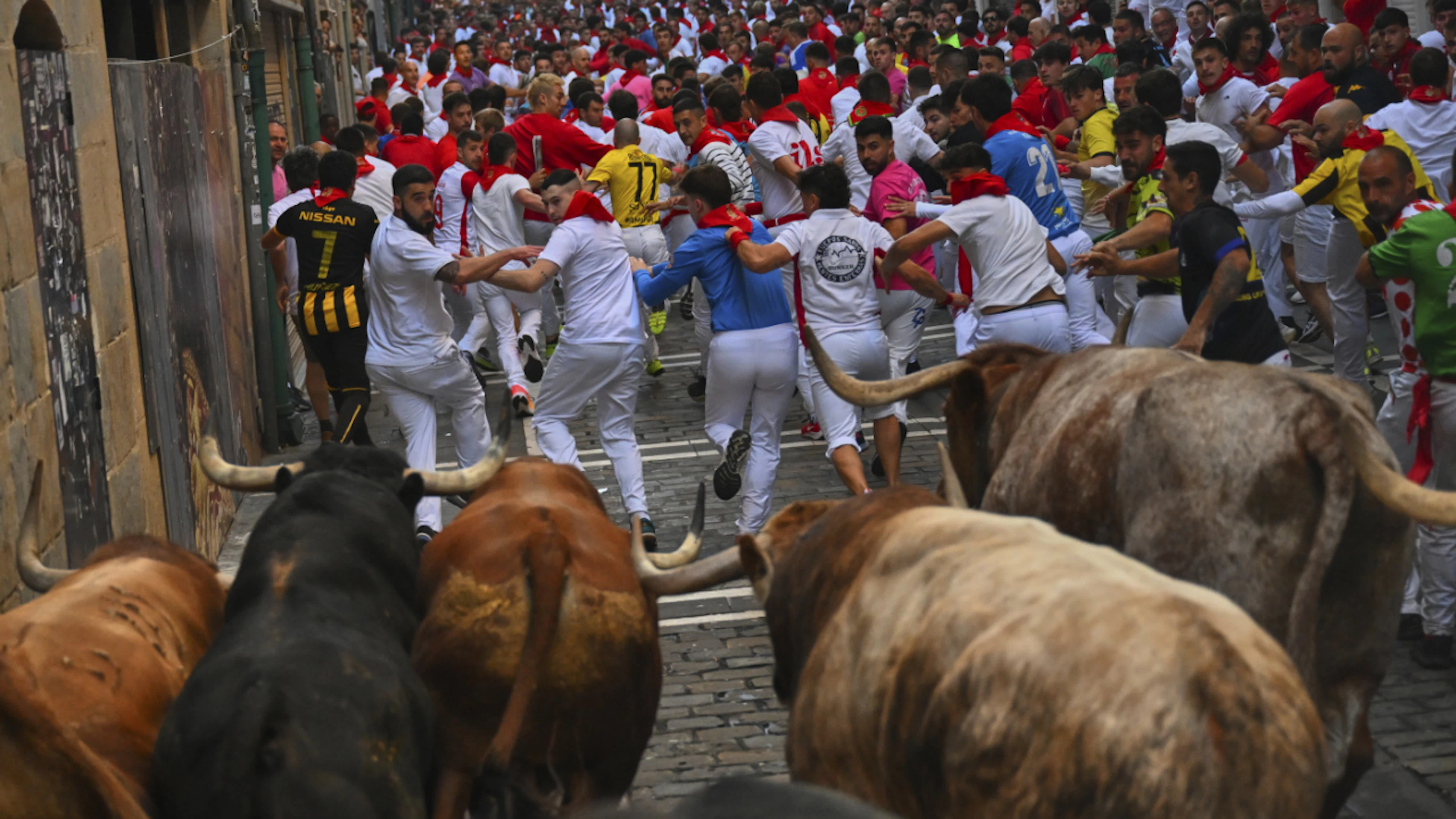 ARCHIV – Teilnehmer treiben die Stiere der Victoriano del RÌo CortÈs Ranch am vierten Tag der SanfermÌn-Festlichkeiten durch die Innenstadt. Foto: Miguel Oses/AP/dpa (Archivbild)