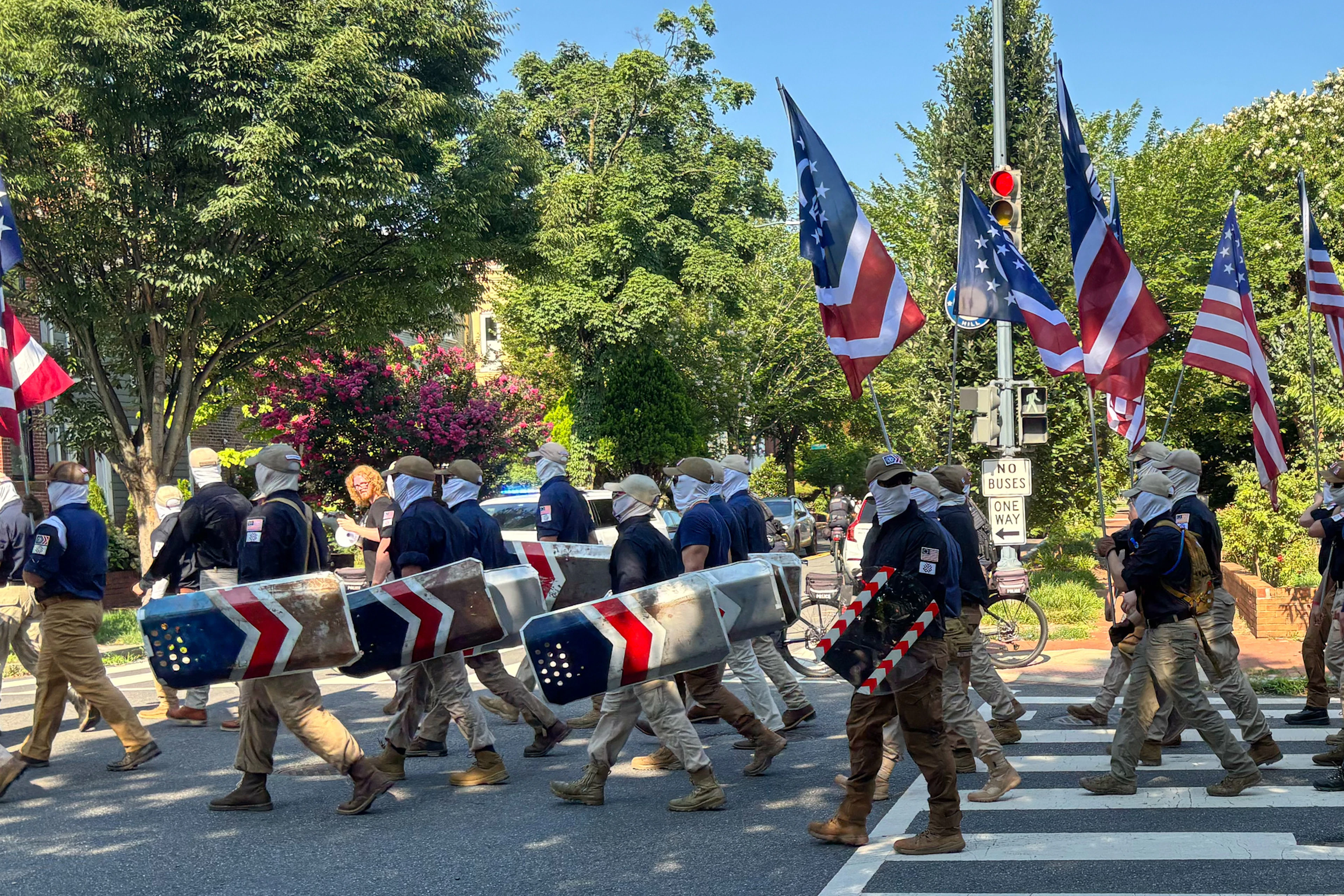 Sur cette photo fournie par Mark Sherman, des membres du groupe Patriot Front, masqués, défilent dans les rues de Washington avant les festivités de la Fête de l'Indépendance célébrant le 250e anniversaire de la nation, samedi 4 juillet 2026.