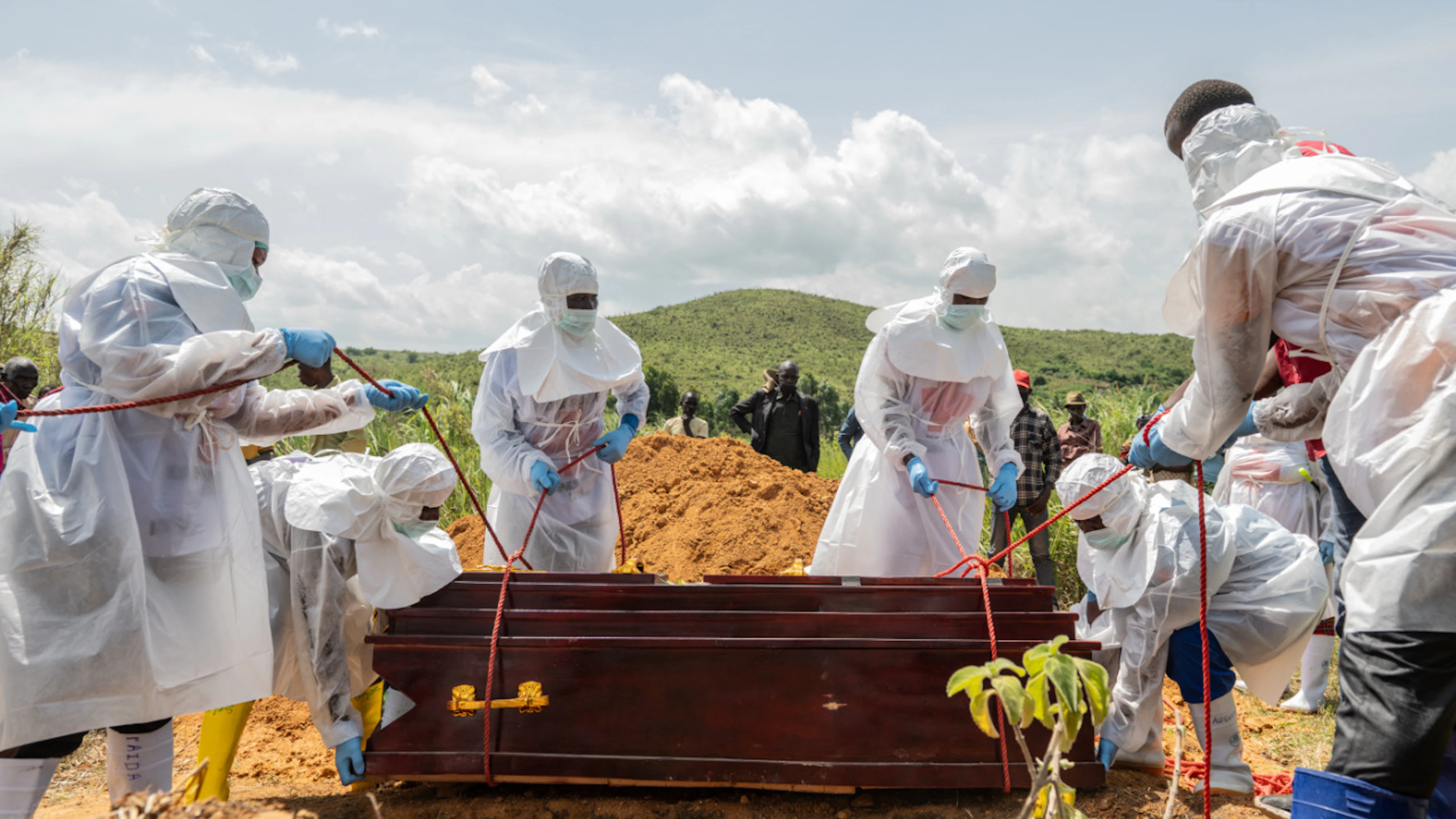 ARCHIV – Mitarbeiter des Roten Kreuzes beerdigen ein Ebola-Opfer auf dem Rwampara-Friedhof. Foto: Moses Sawasawa/AP/dpa