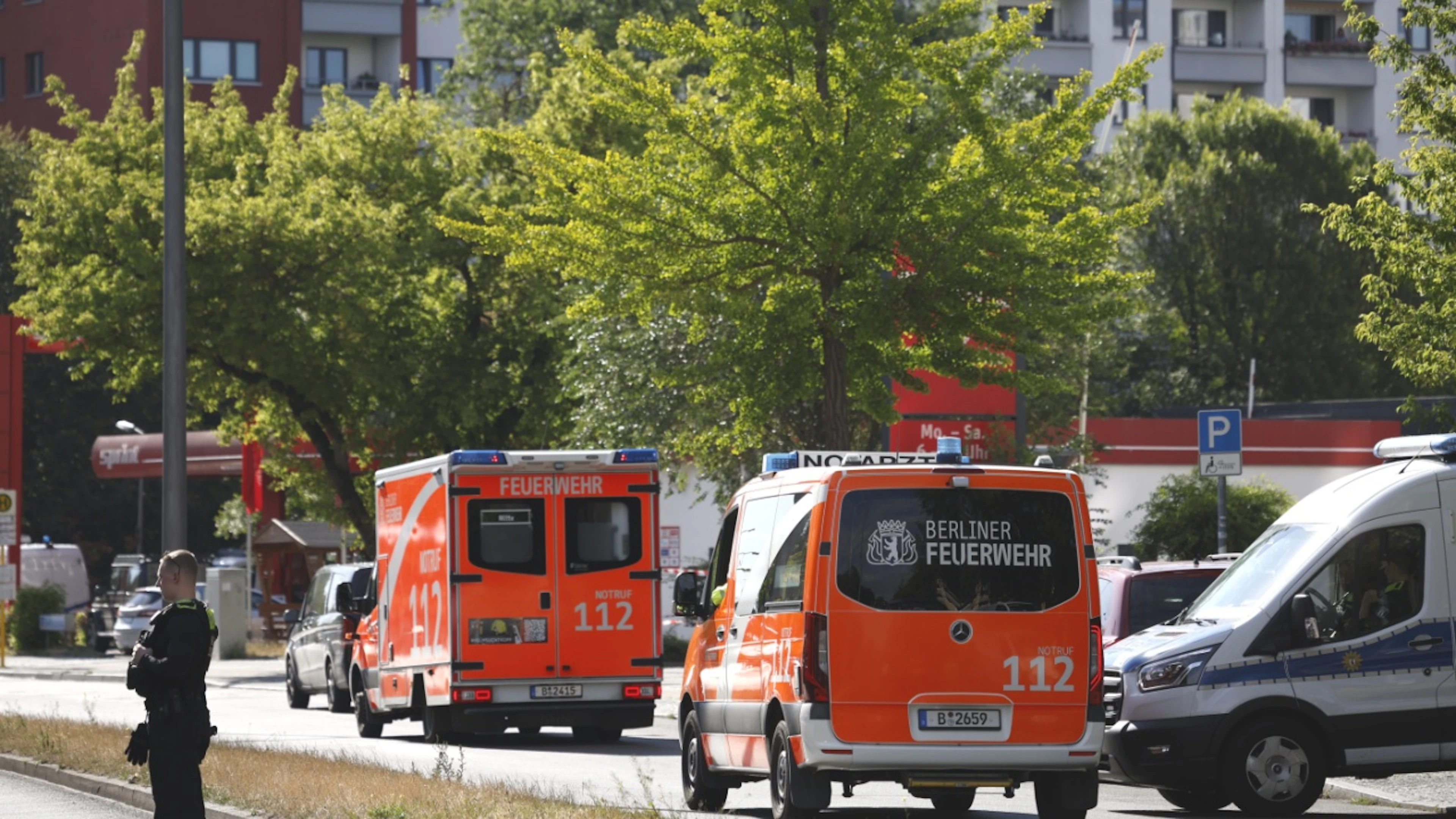 Krankenwagen stehen in der Nähe von einem Supermarkt bereit. In dem Supermarkt im Süden Berlins hält ein Mann seit dem späten Freitagabend eine Frau als Geisel. Foto: Carsten Koall/dpa