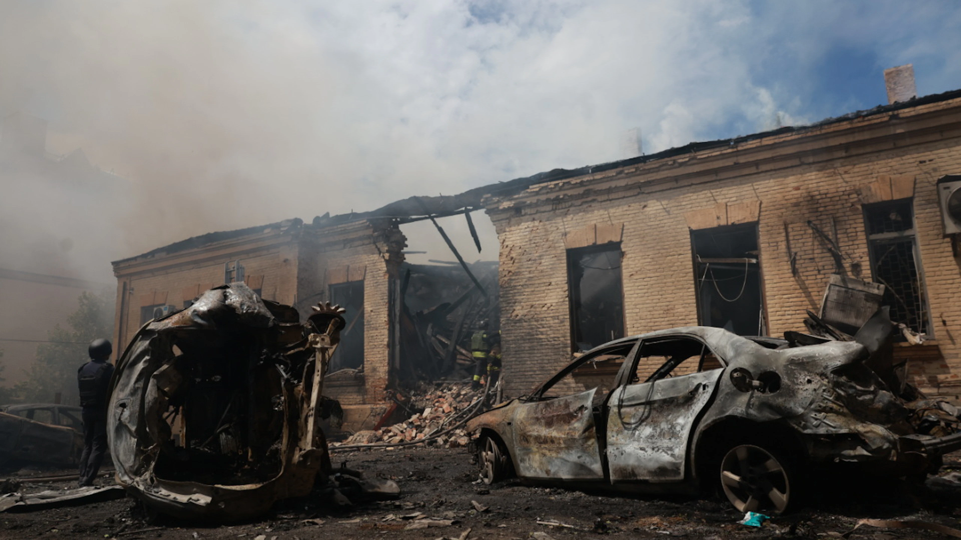 ARCHIV – Rettungskräfte löschen einen Brand in einem Gebäude, das bei einem russischen Angriff auf Saporischschja zerstört wurde. Foto: Evgeniy Maloletka/AP/dpa/Symbolbild
