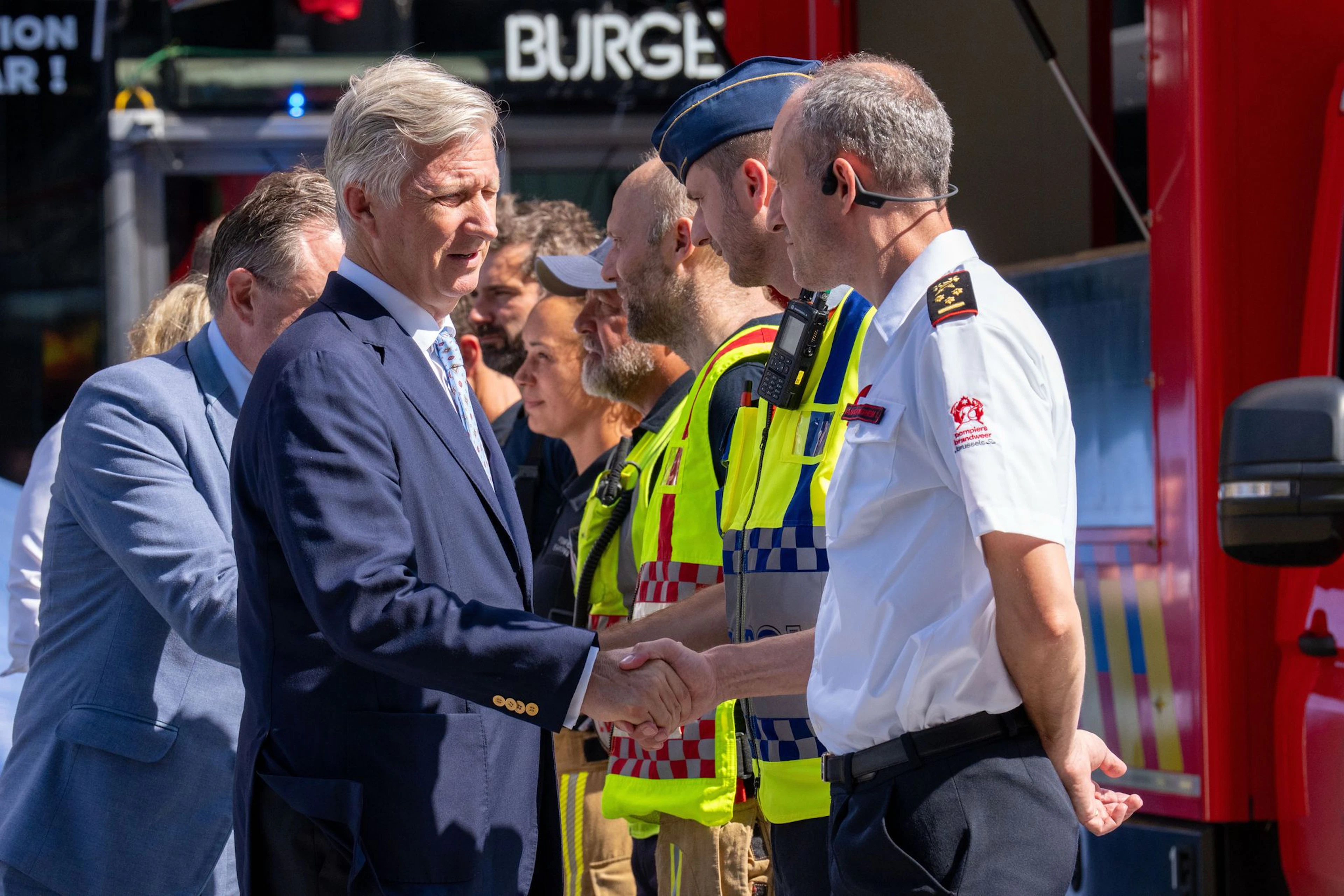 Der belgische König Philippe (vorne) und Ministerpräsident Bart De Wever bedanken sich bei Rettungskräften. 