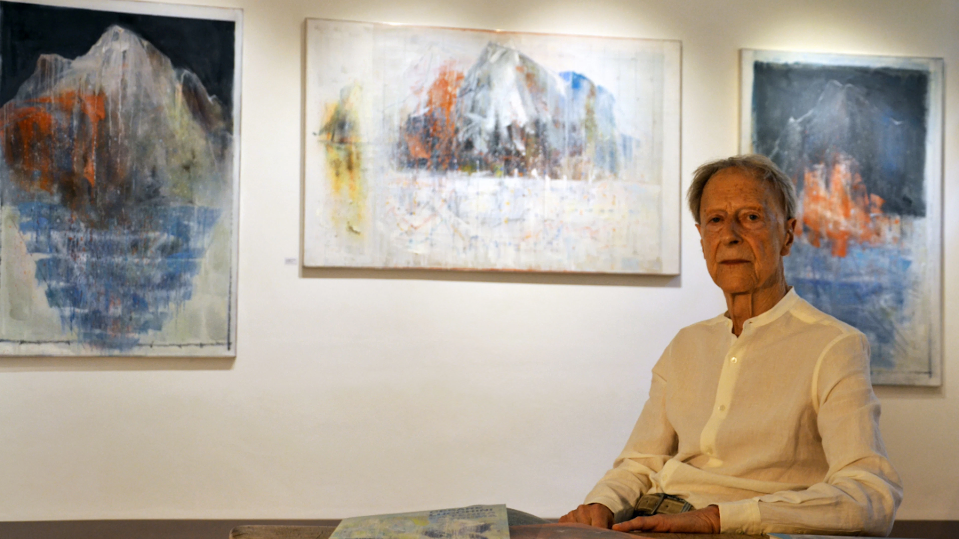 L'artista ticinese Cesare Lucchini nella galleria del Museo Engadinese a St. Moritz. Sullo sfondo si vedono alcuni quadri esposti nella mostra «La montagna ammalata».