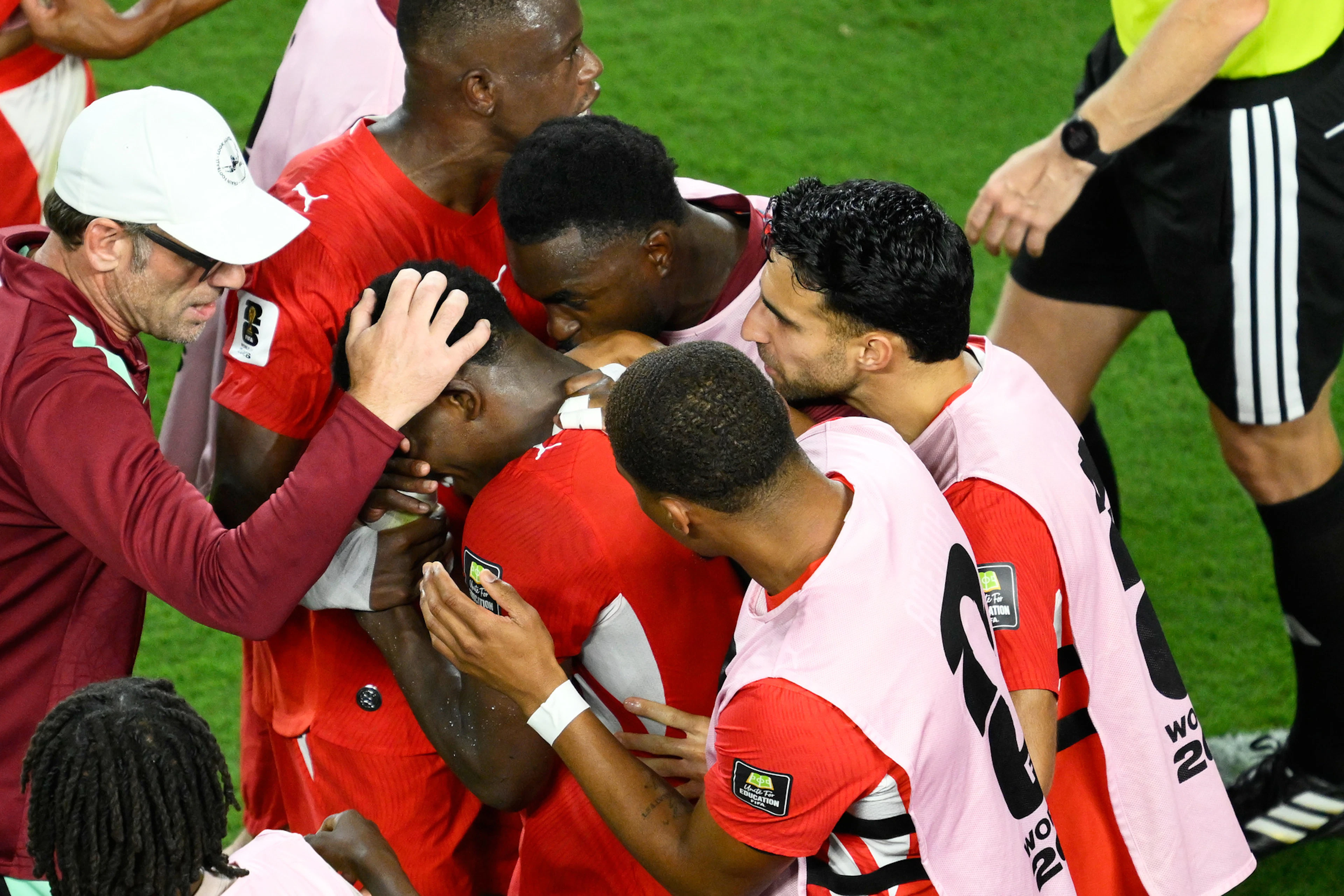 A visibly distraught Breel Embolo is comforted by his teammates as he leaves the field.