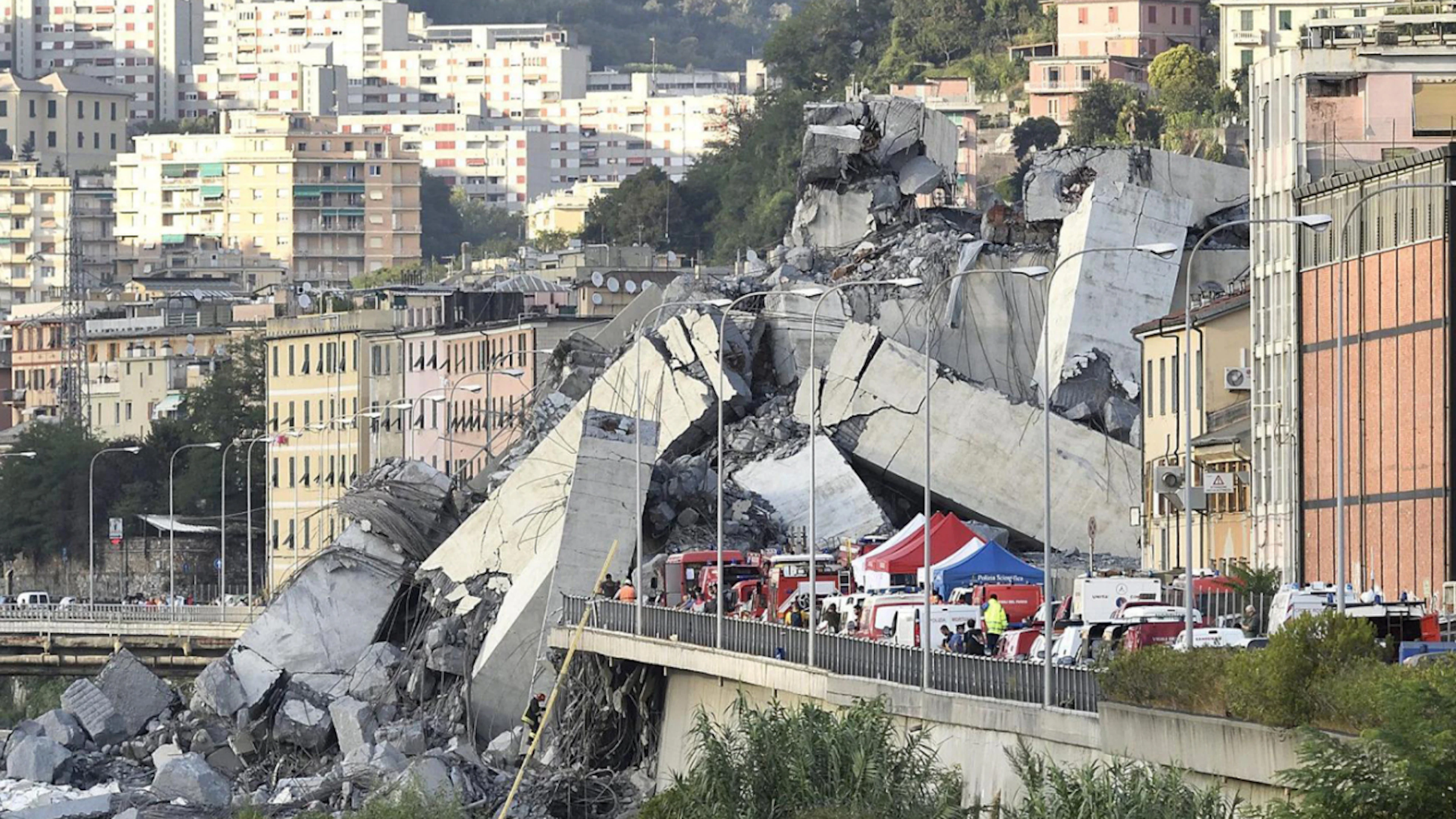 ARCHIVE – Emergency vehicles are parked in front of the partially collapsed highway bridge. In 2018, 43 people lost their lives when the “Ponte Morandi” collapsed over a length of about 100 meters. Photo: Luca Zennaro/ANSA/AP/dpa