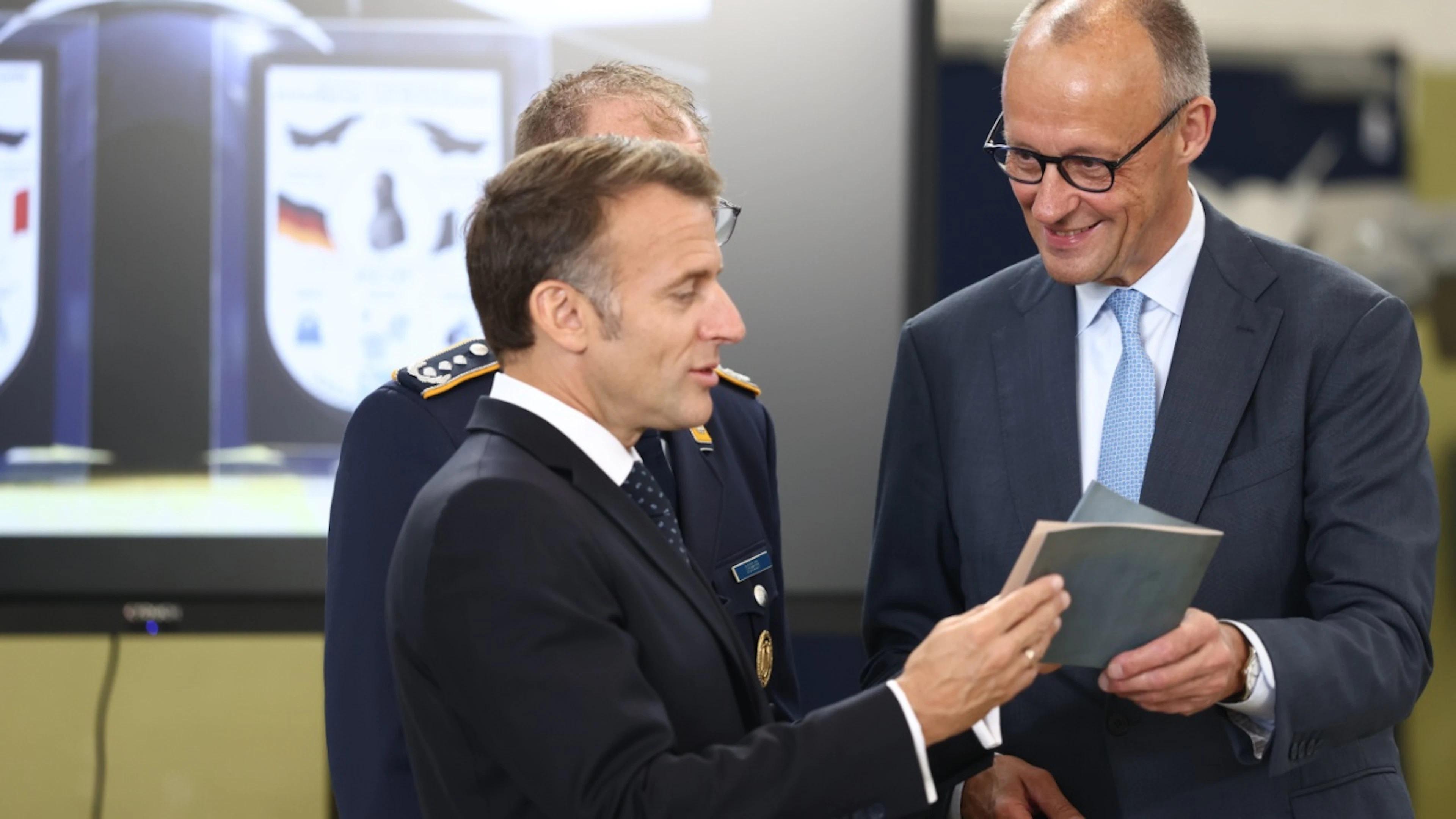 Emmanuel Macron, President of France, and Federal Chancellor Friedrich Merz (right, CDU) are holding a historic book on aviation. Photo: Rolf Vennenbernd/dpa