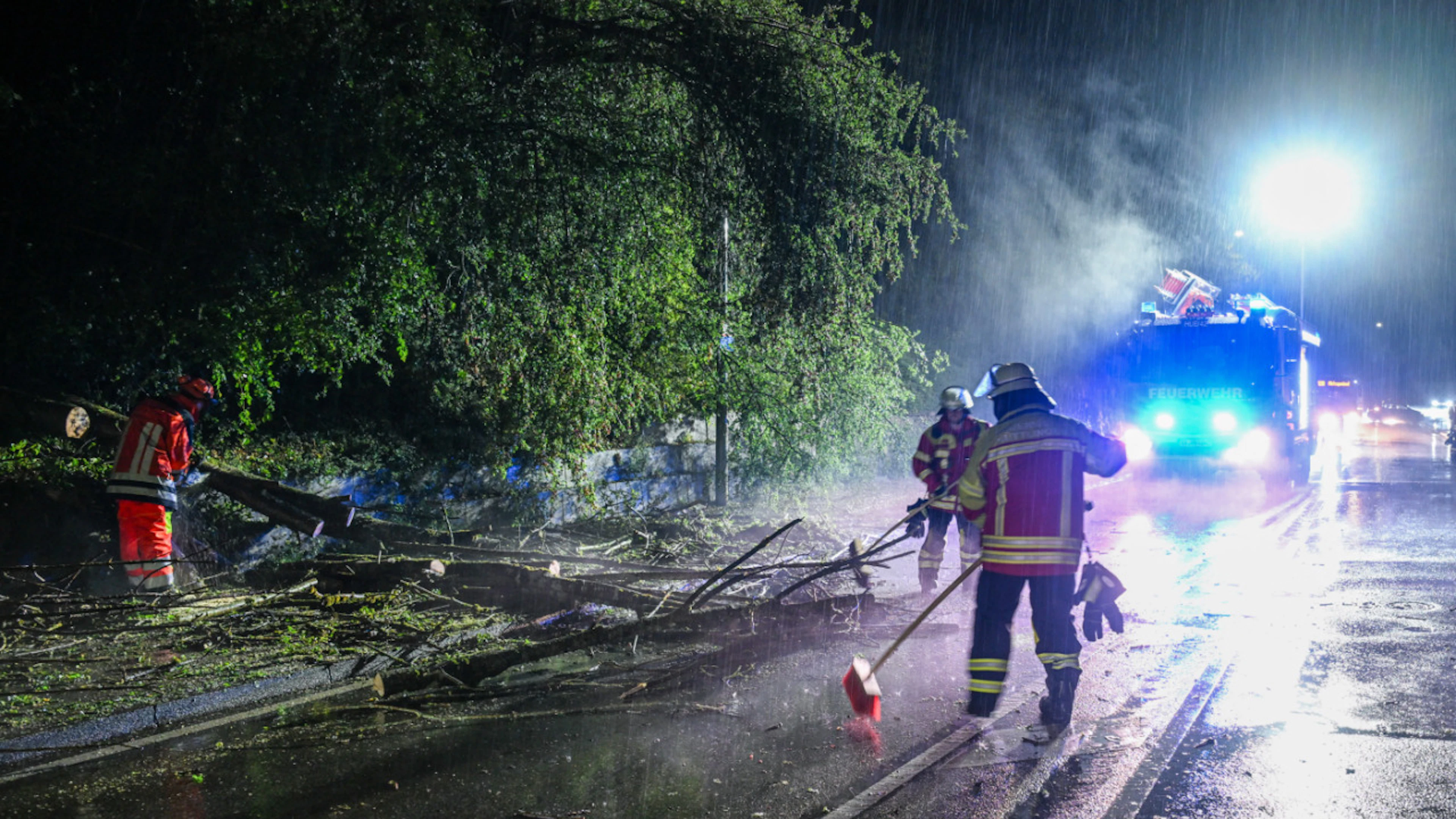 Die Feuerwehr befreit eine Strasse von einem umgestürtzten Baum im Ostalbkreis. Foto: Jason Tschepljakow/dpa