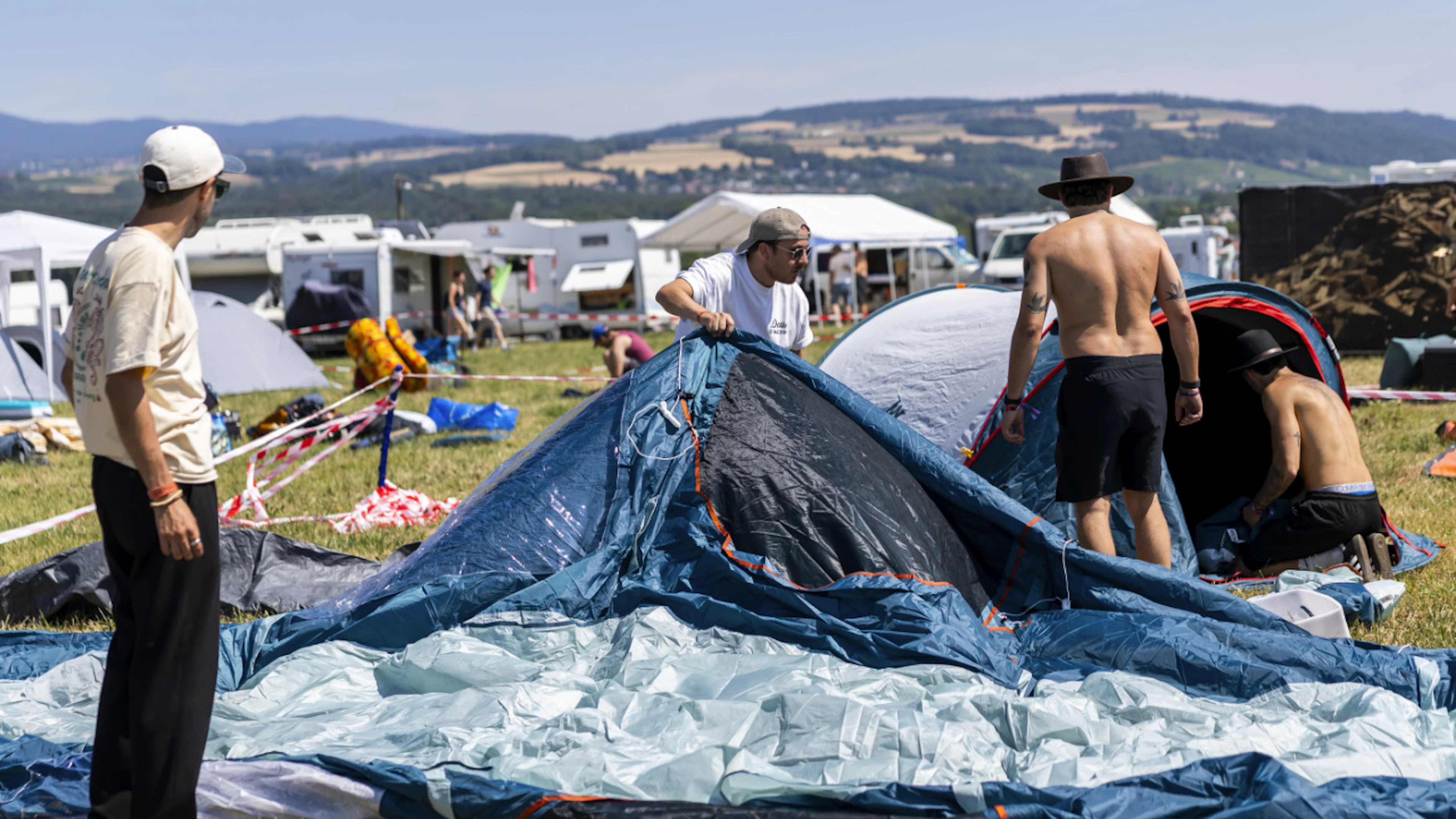 Die ersten Festivalbesucher stellen ihre Zelte auf.