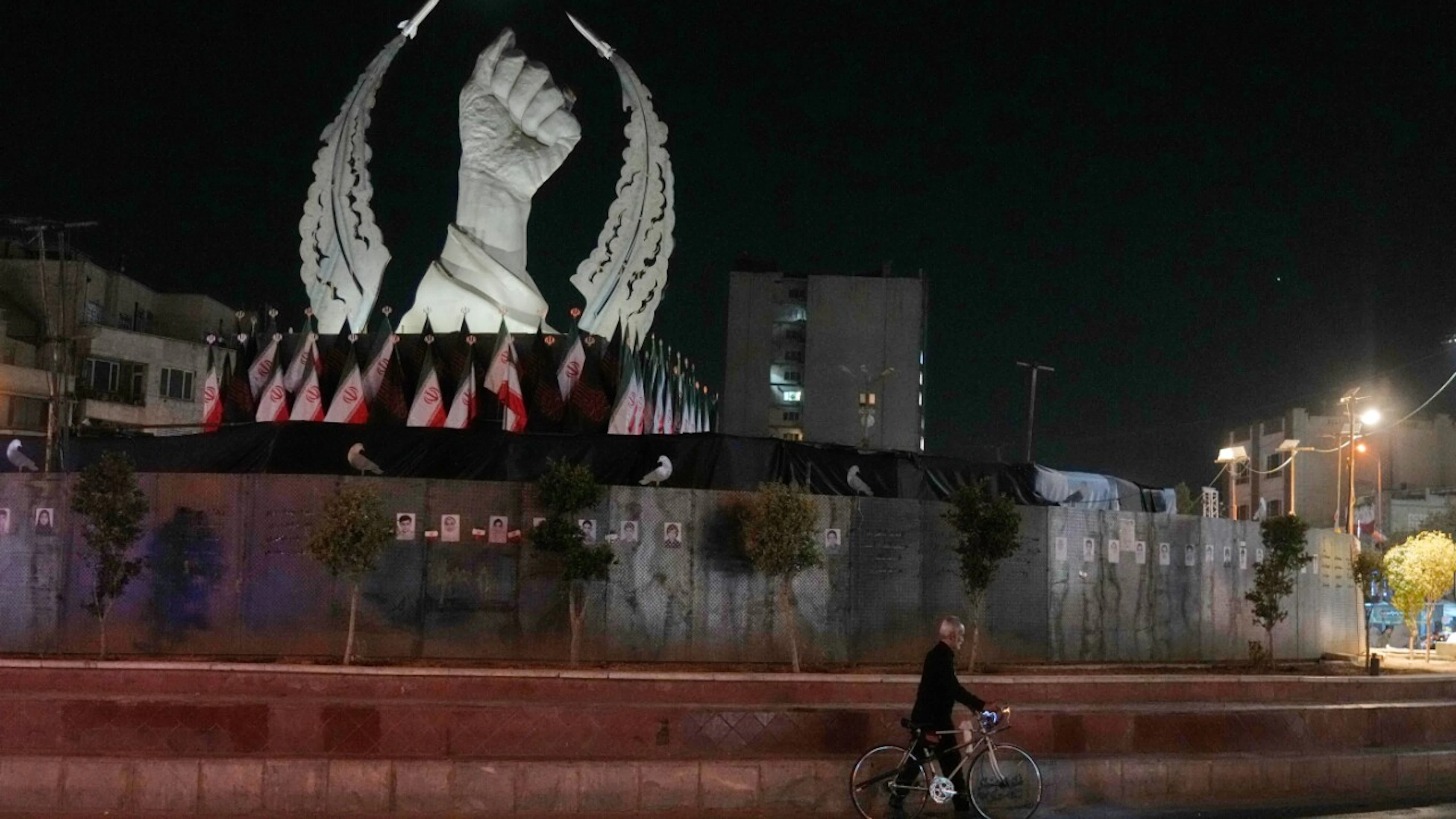 A man pushes his bicycle in front of a monument on Islamic Revolution Square in Tehran. Photo: Vahid Salemi/AP/dpa