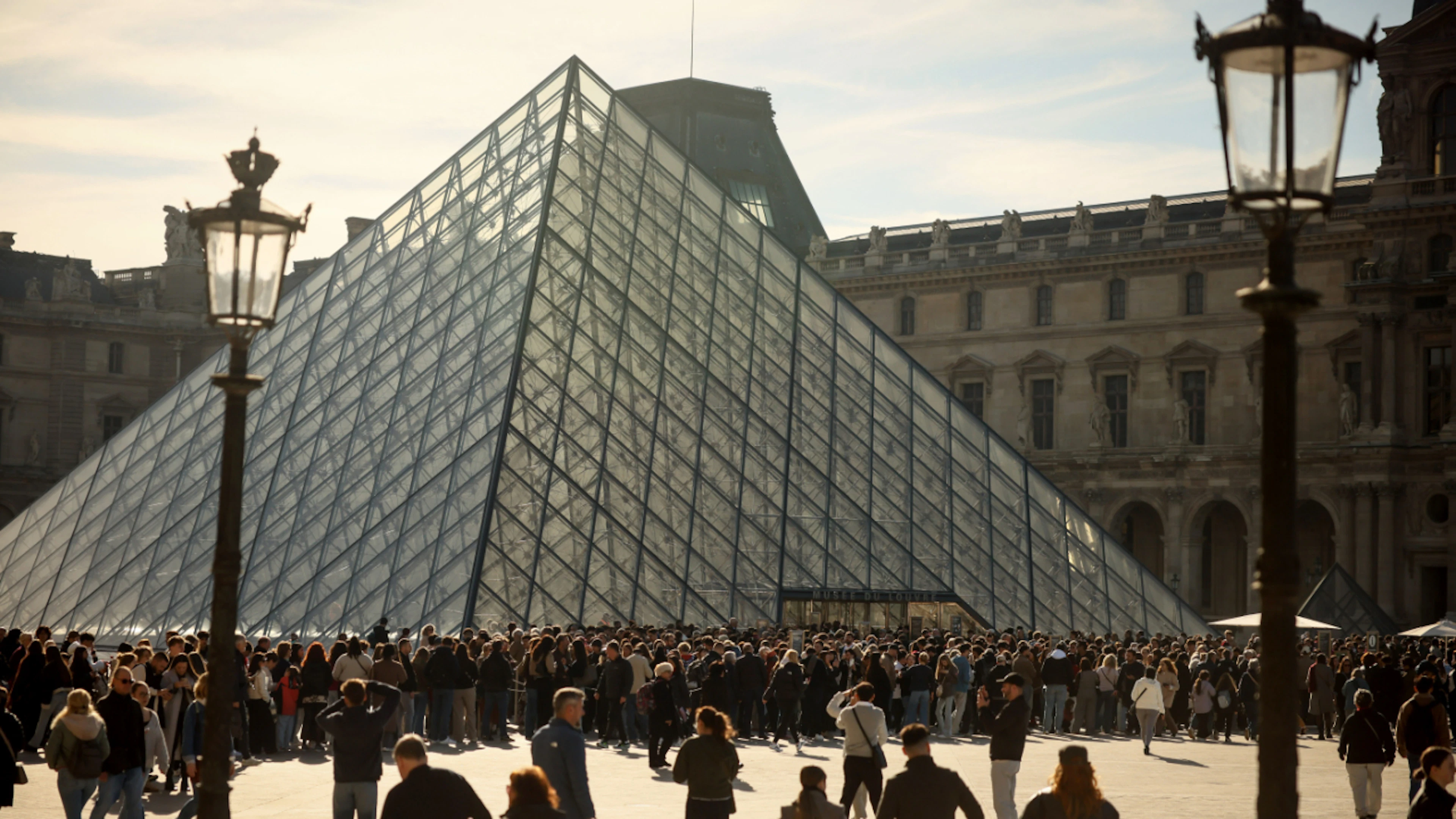ARCHIVE – People are lining up outside the Louvre Museum. Nine months after the spectacular break-in, the museum is reopening the Galerie d'Apollon. Photo: Thomas Padilla/AP/dpa