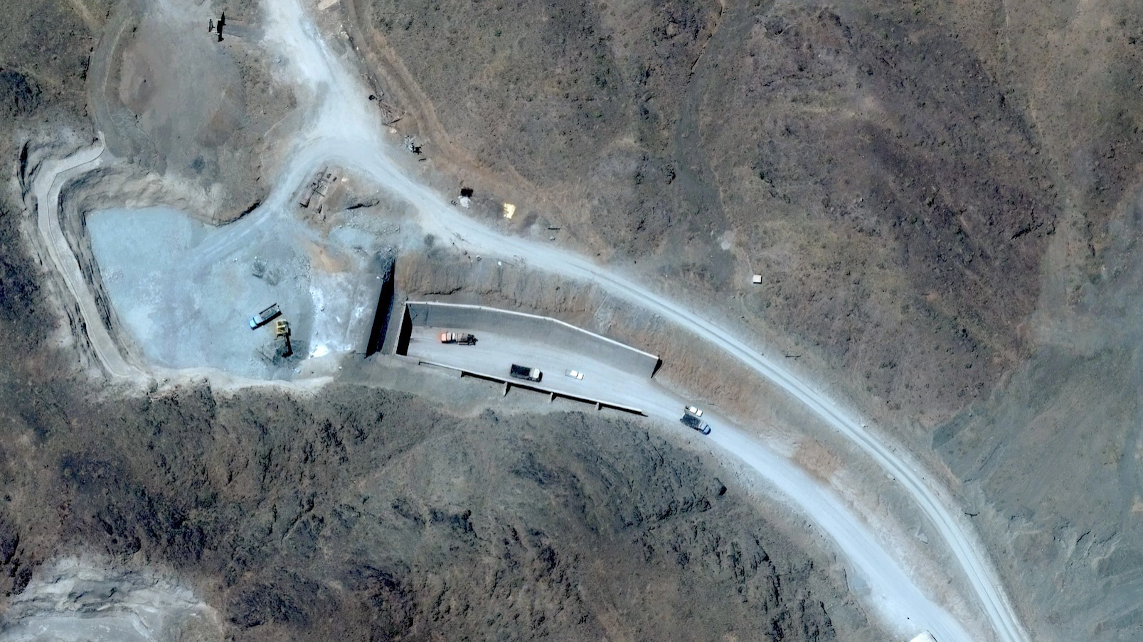 Ein Satellitenbild zeigt Fahrzeuge am westlichen Tunneleingang von «Pickaxe Mountain», dem stark befestigten Tunnelsystem im Berg Kuh-e Kolang rund um die iranischen Atomanlagen. (21. Juni 2026)