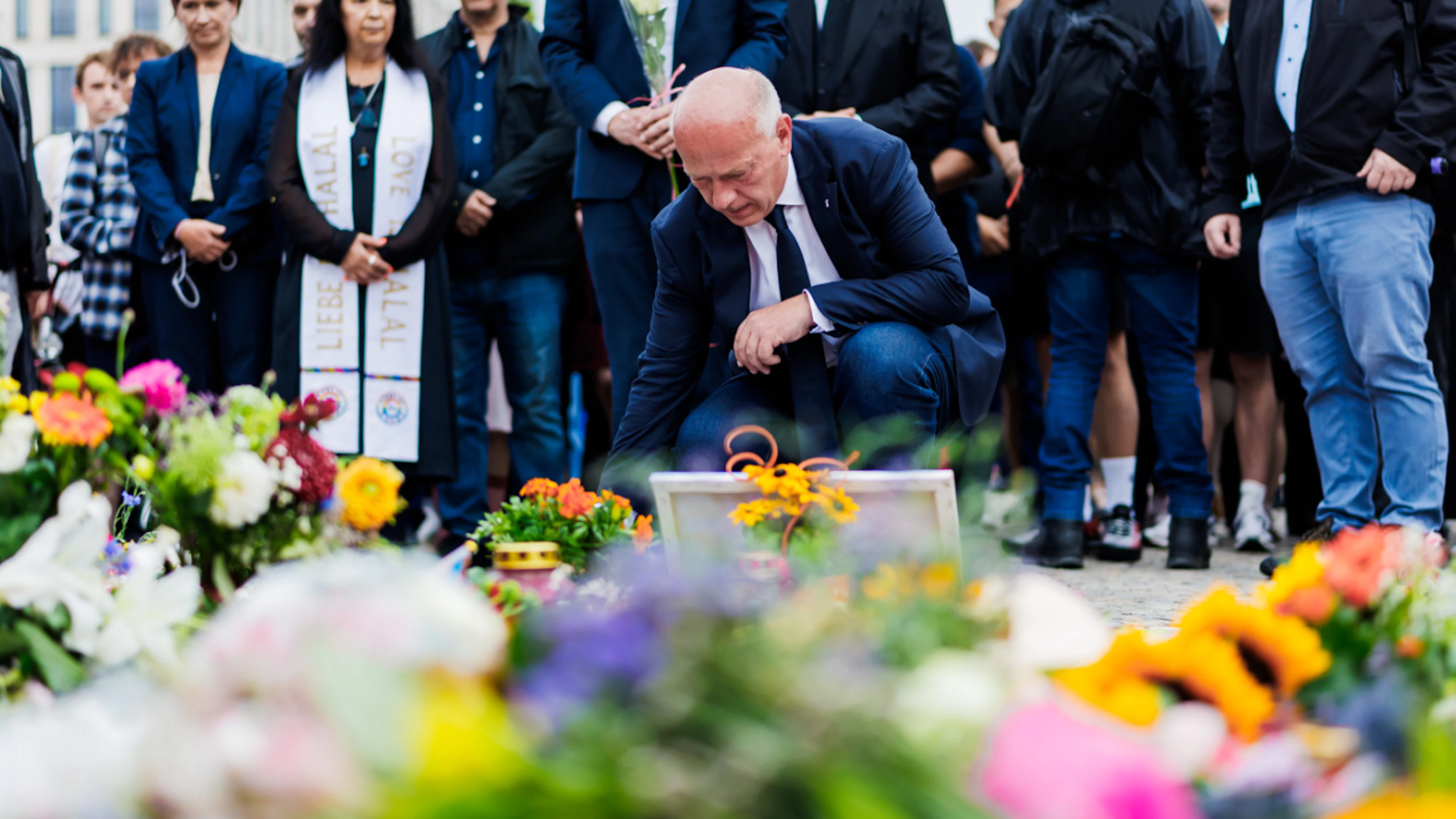 Kai Wegner (CDU, M), Regierender Bürgermeister von Berlin, legt beim Gedenken nach der Tat am Rande des CSD Blumen ab. Foto: Christoph Soeder/dpa