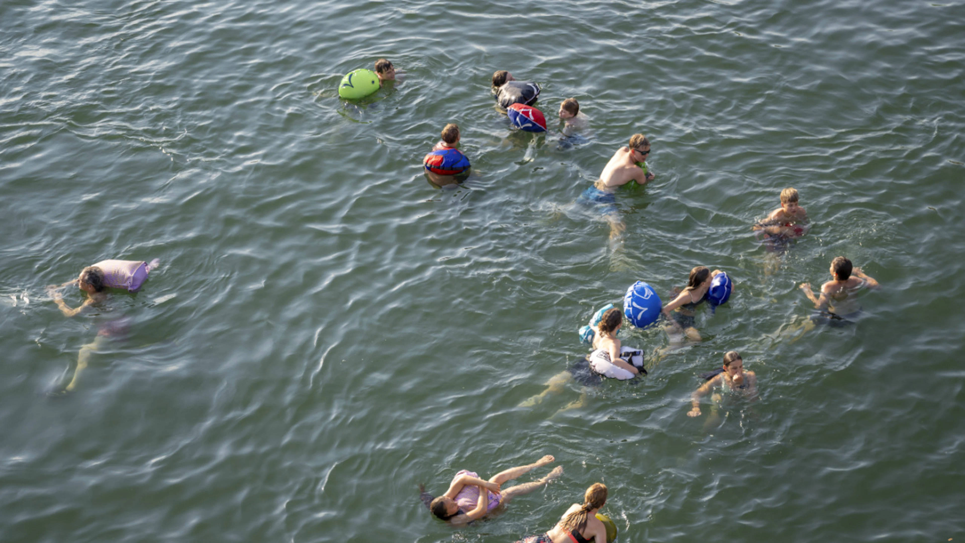 People are swimming in the Rhine near Basel. Temperature records were broken in several locations across Switzerland on Wednesday. (File photo)