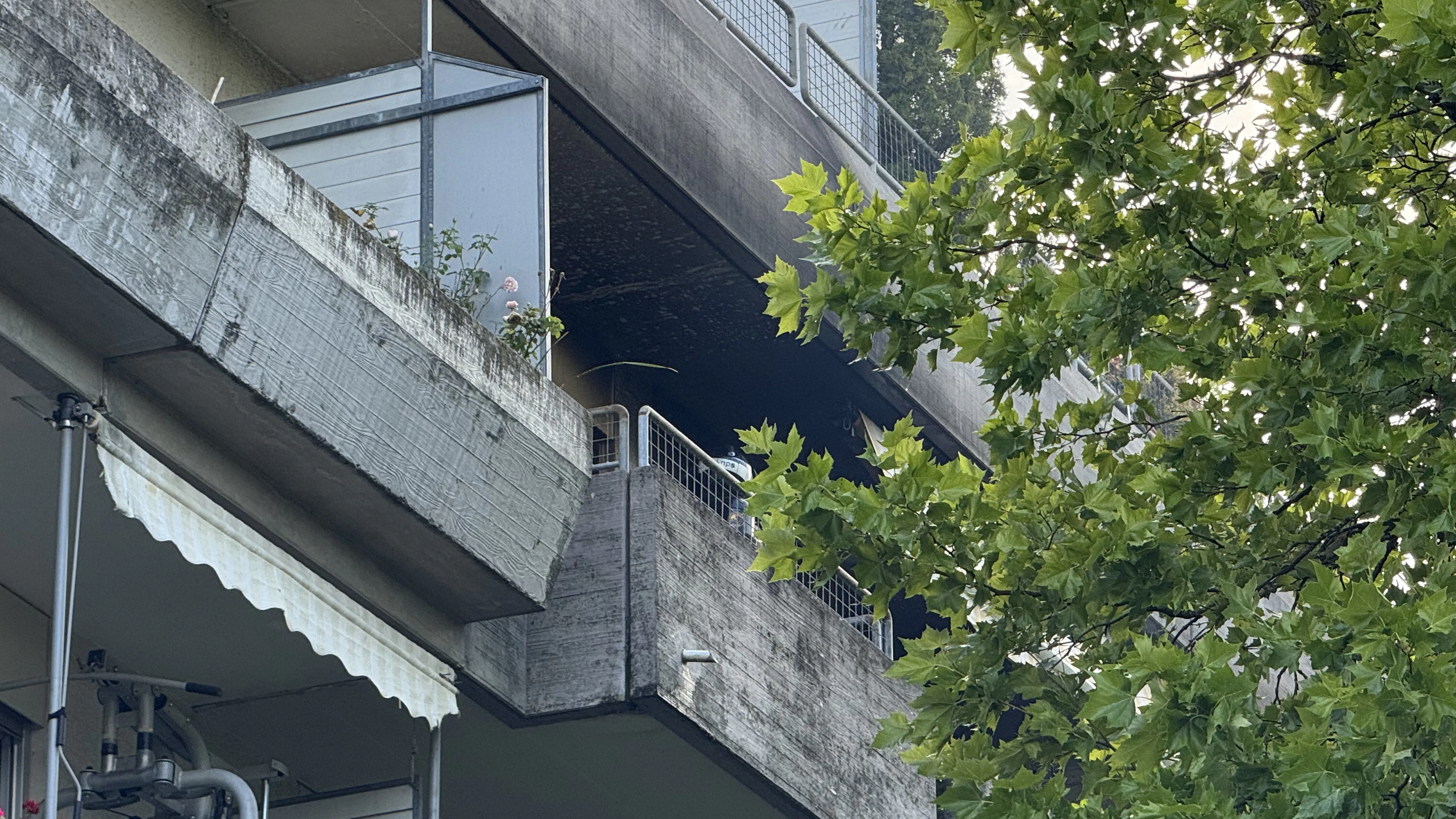 The fire broke out in an apartment on one of the upper floors of the apartment building. The apartment shows clear signs of soot damage following the fire.