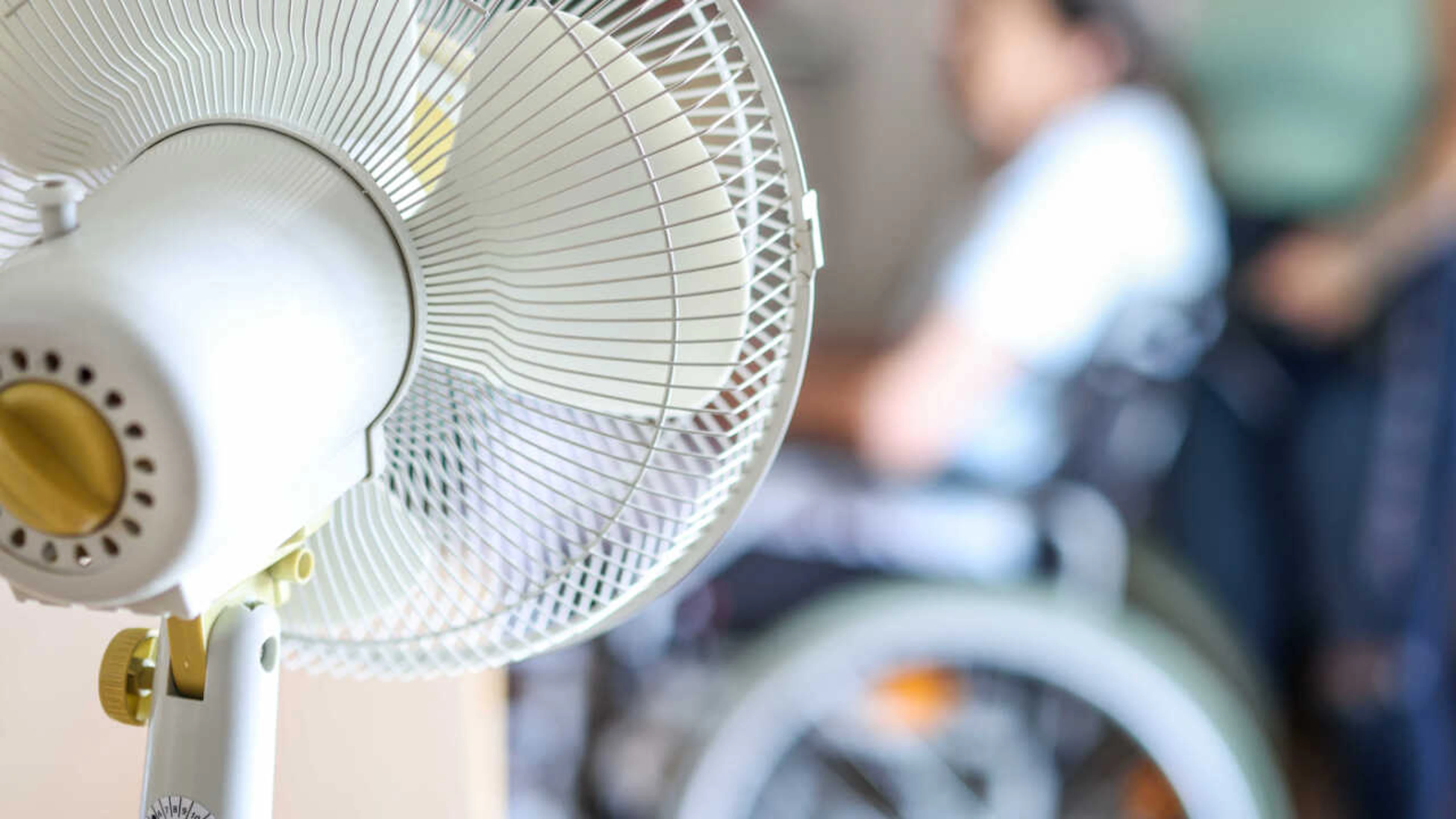 ARCHIVE – A fan stands in a common room at a retirement home; an elderly woman in a wheelchair is sitting in front of it. Photo: Christoph Reichwein/dpa