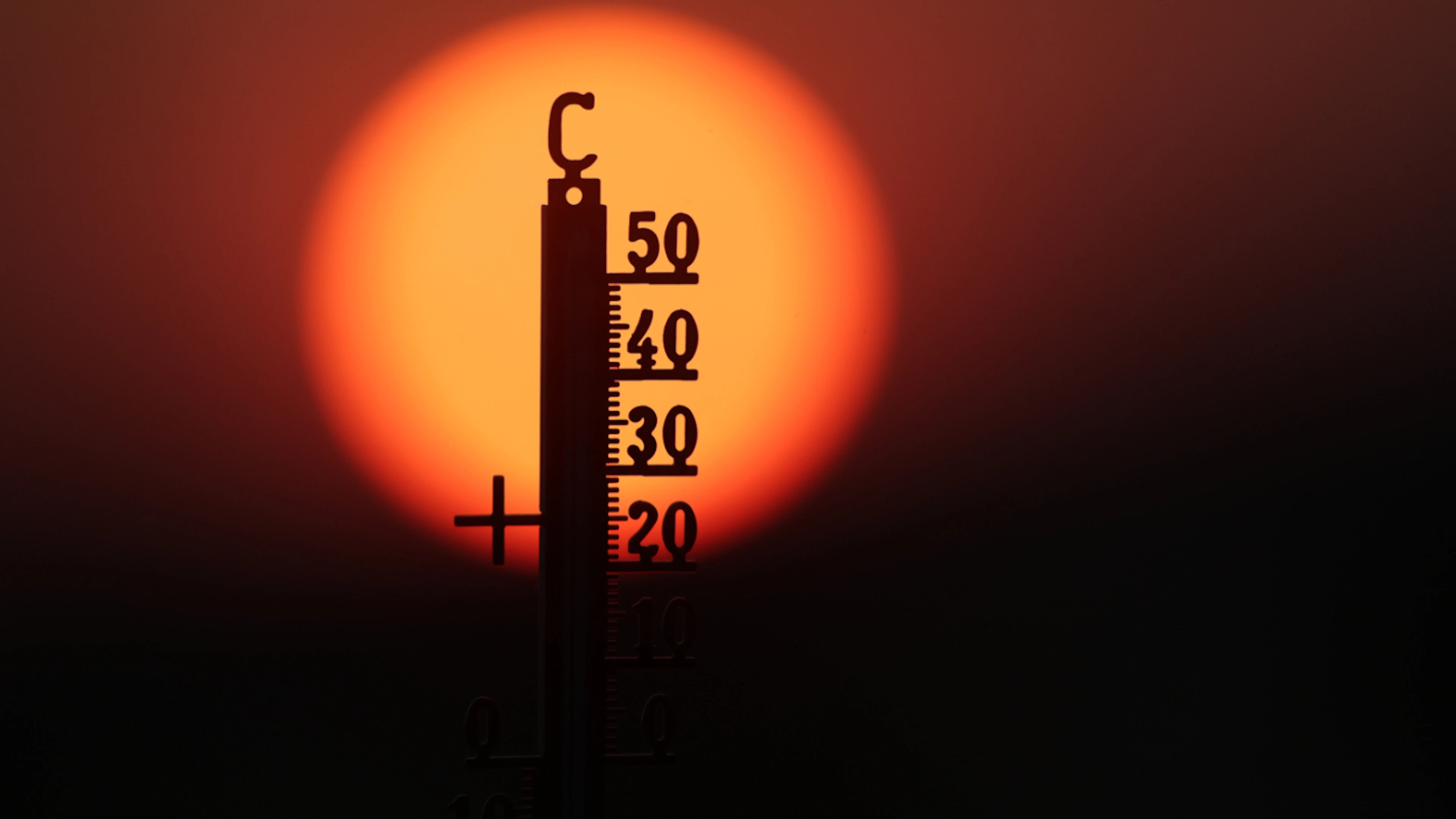 ARCHIVE – The sun rises behind a thermometer in the morning. Photo: Thomas Warnack/dpa