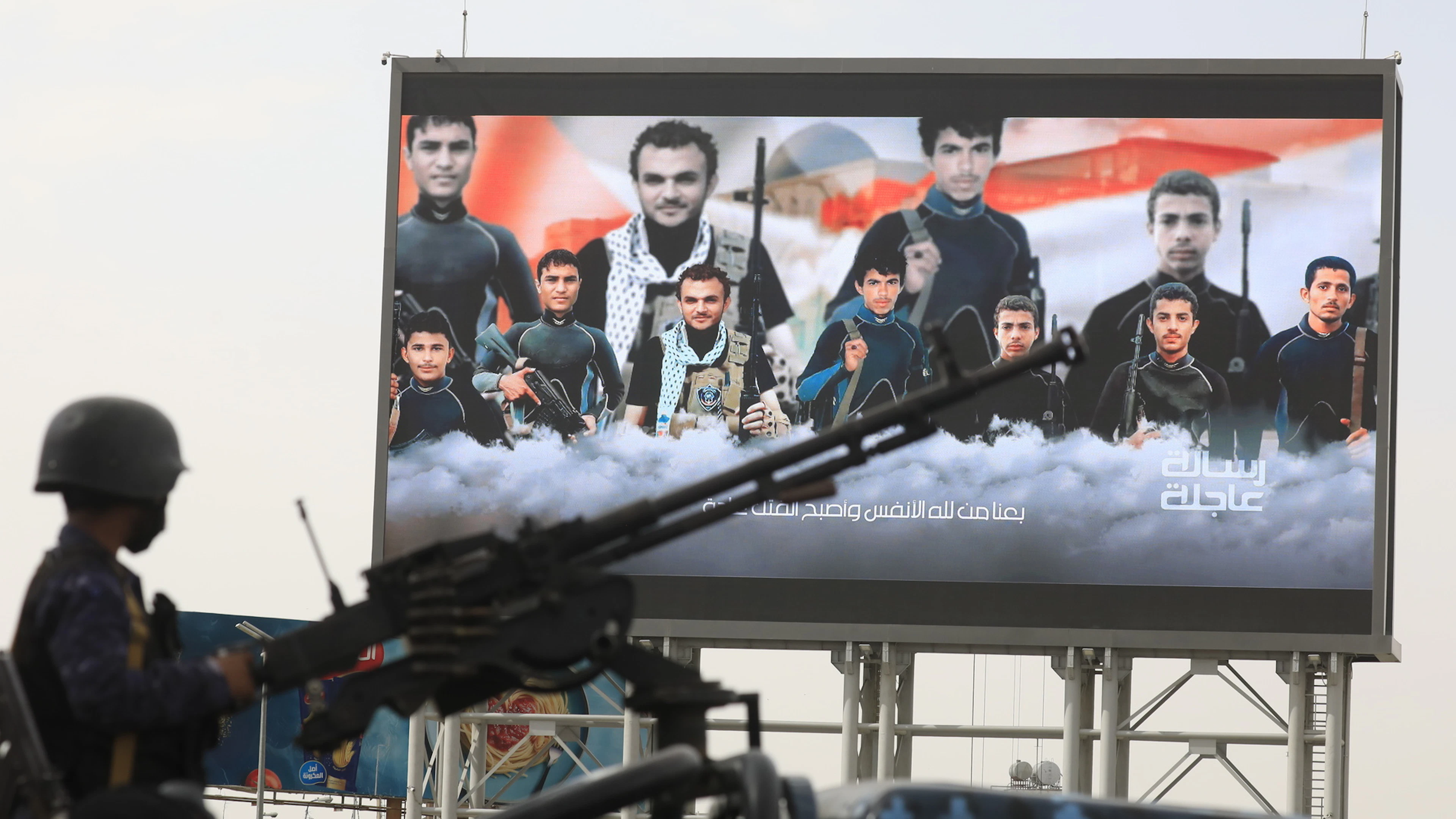 Protestkundgebung gegen Saudi-Arabien in Sanaa: Ein Huthi-Kämpfer mit einem Maschinengewehr auf der Ladefläche eines Pick-ups vor einer digitalen Anzeigetafel mit Bildern von Huthi-Kämpfern, die bei US-Angriffen im Roten Meer getötet wurden. (31. Juli 2026)